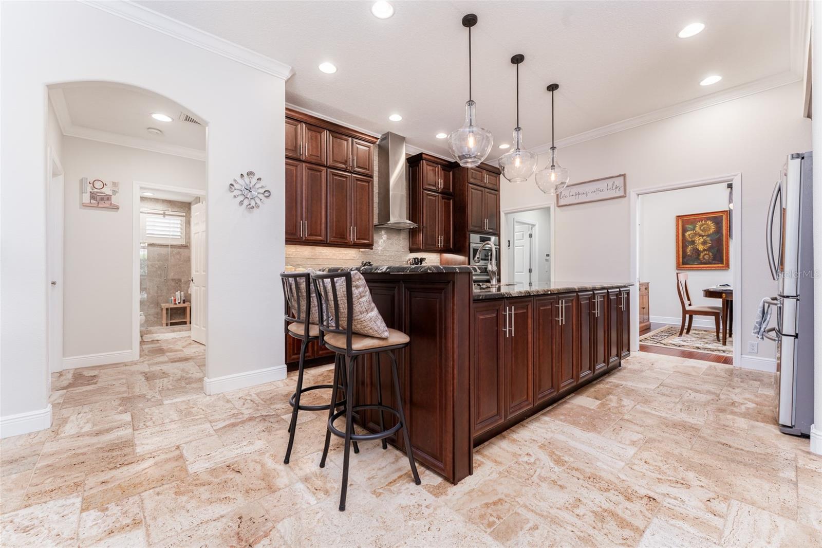 Chef Inspired Kitchen with Beautiful Wood Cabinets, Stone Tops, Pretty Pendant Lighting, Tile Backsplash, Under Cabinet Lighting