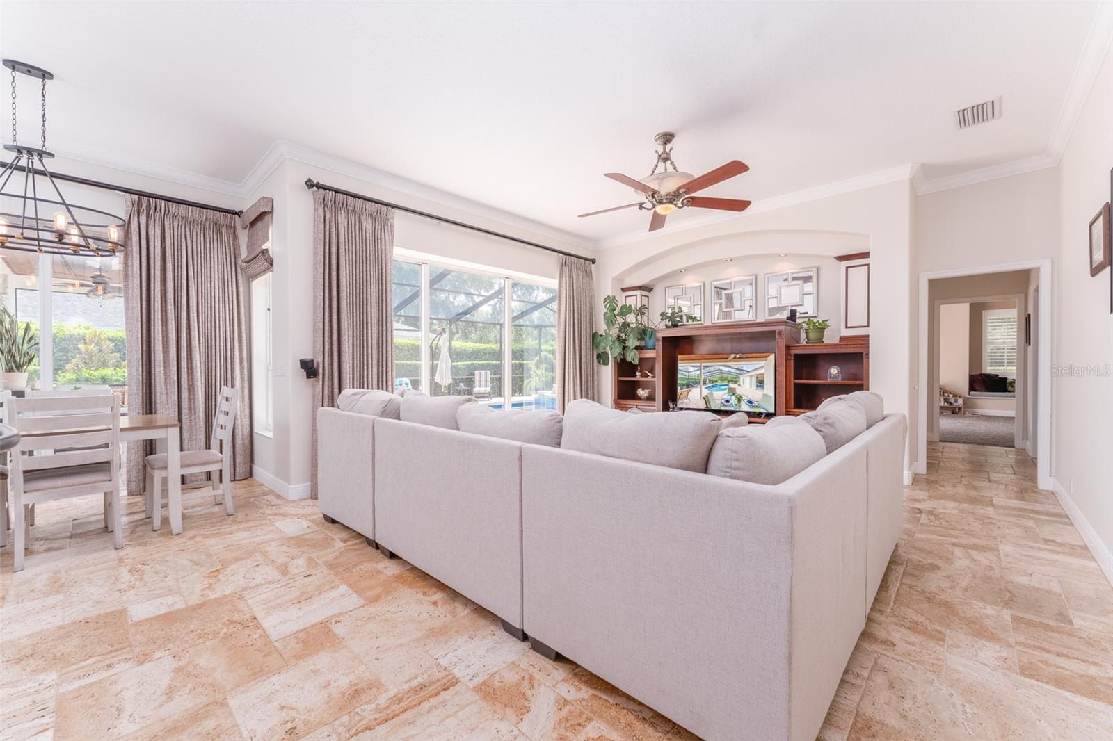 Spacious Family Room with Quality Built in Cabinetry Overlooks Outdoor Space Accessible Through Sliders