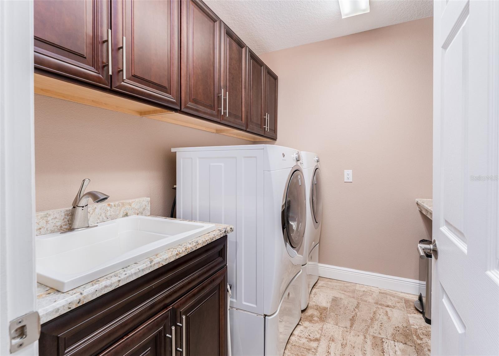 Laundry Room with Washer, Dryer, Wood Cabinetry, Built in Utility Sink and Folding Shelve