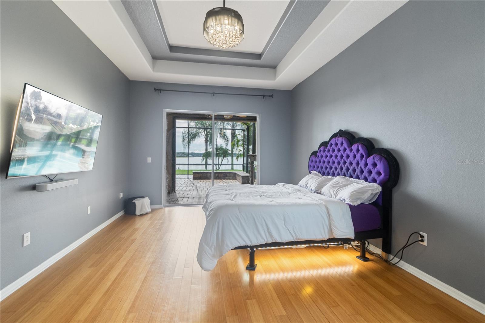 Primary bedroom with a tray ceiling and access to your screened in lanai