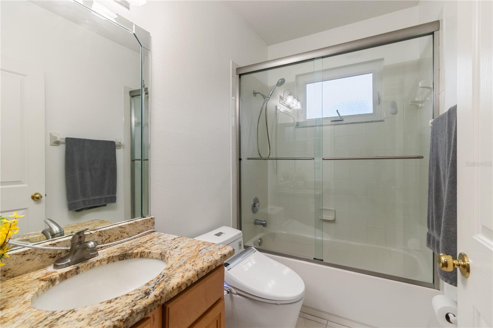 Bathroom 2 with granite countertops, electric bidet, and shower/bath combo