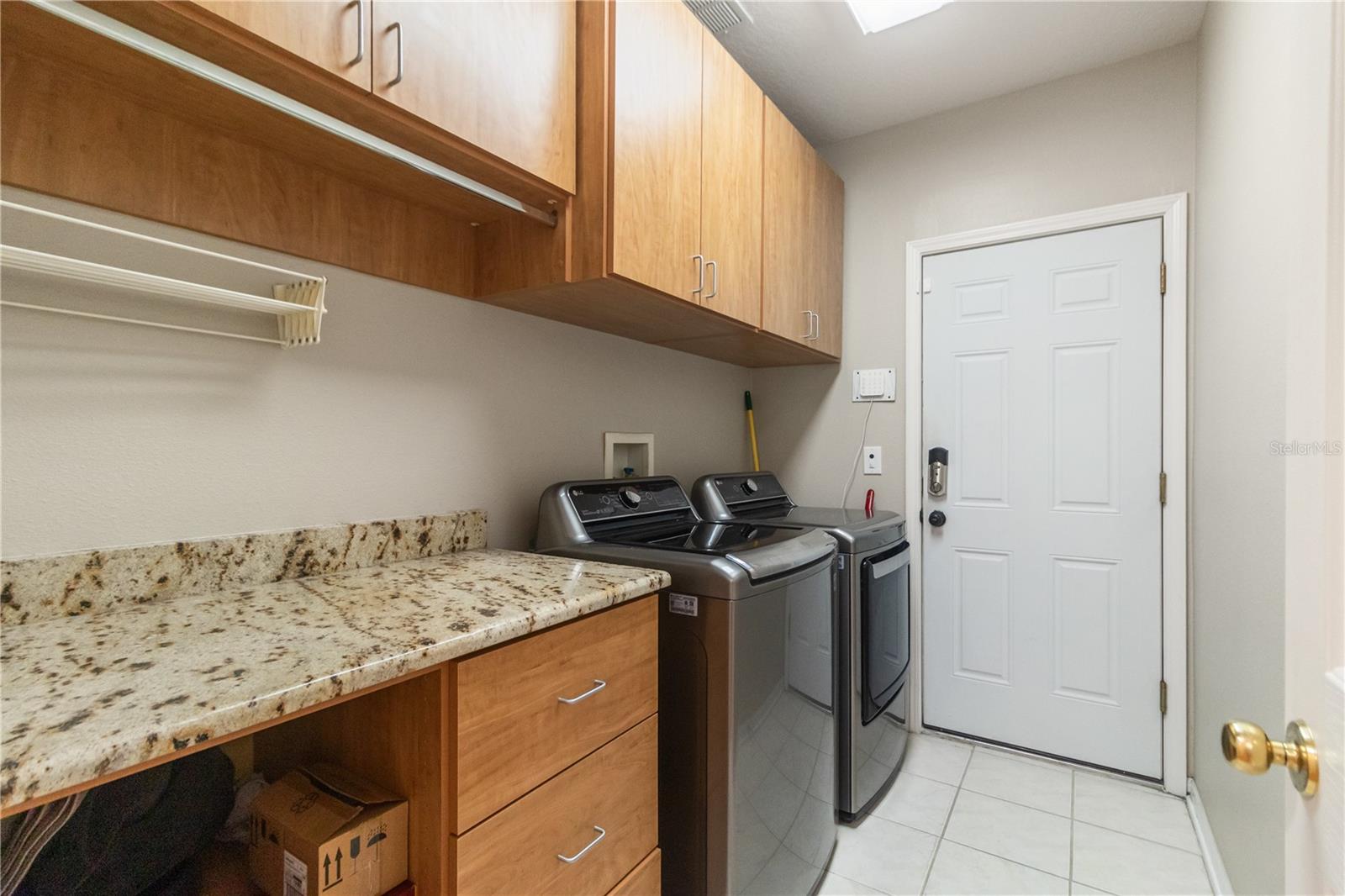 inside laundry room with washer and dryer included and granite countertops with cabinets