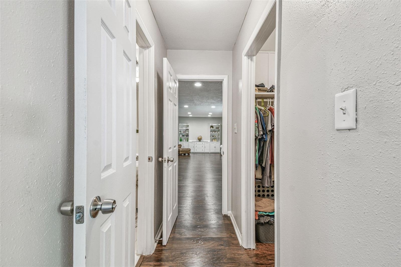 Hallway leading from the primary suite into the living room.