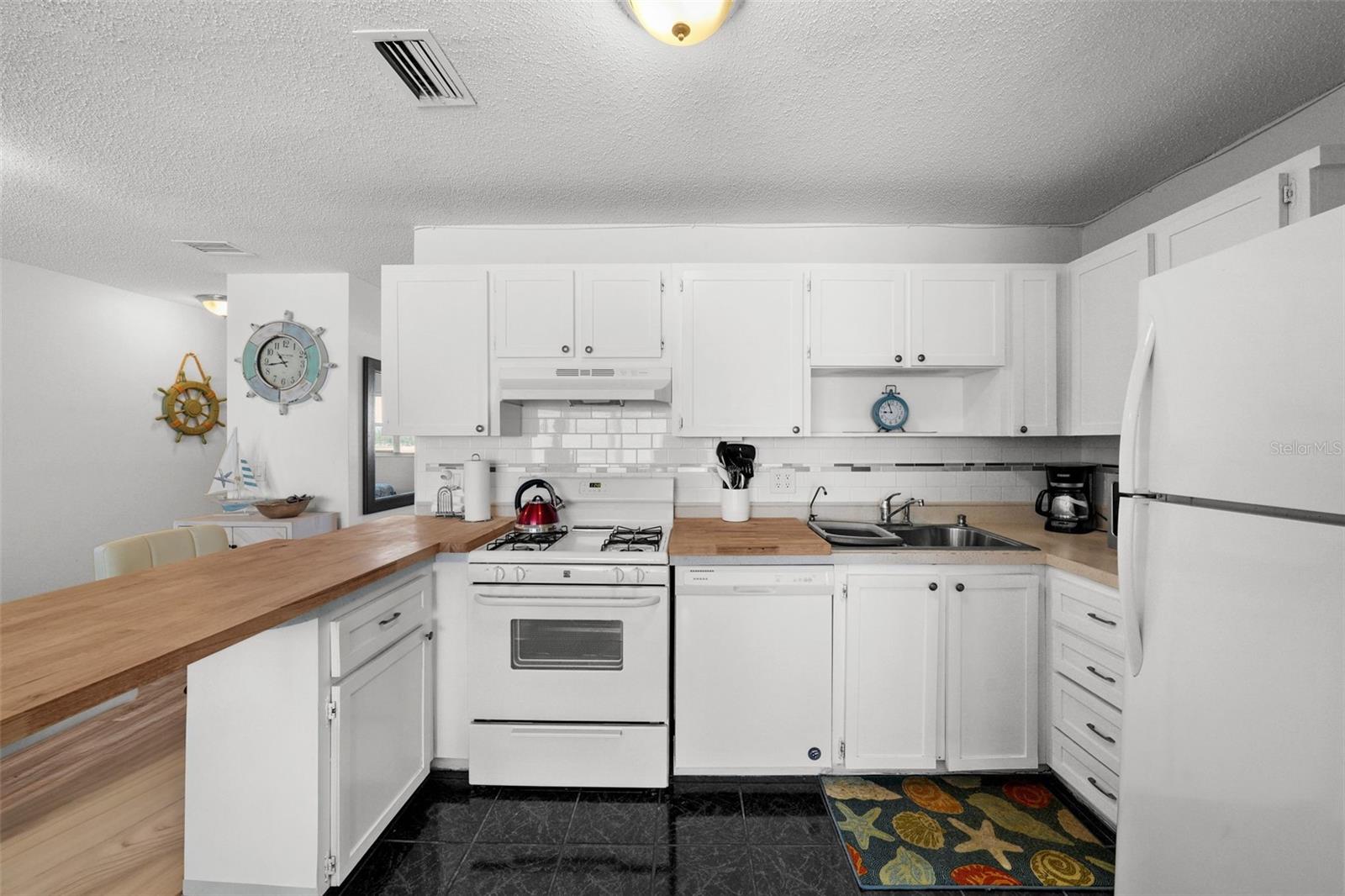 Timeless white cabinetry and backsplash make it simple to add your own pops of color!
