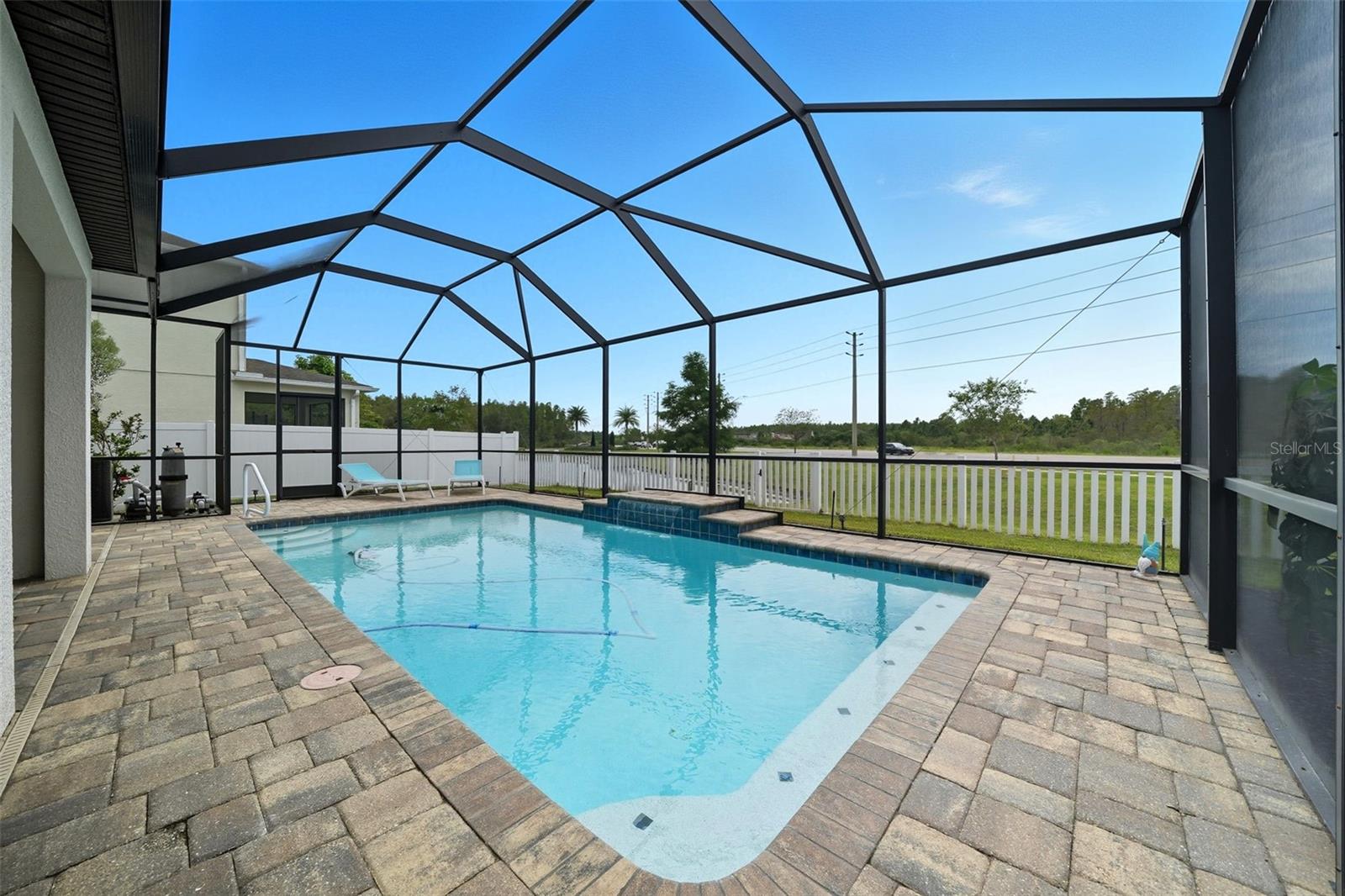 Relax or entertain in style! The screened pool area offers a tranquil water feature, paver decking for loungers, and private conservation views — the perfect outdoor retreat