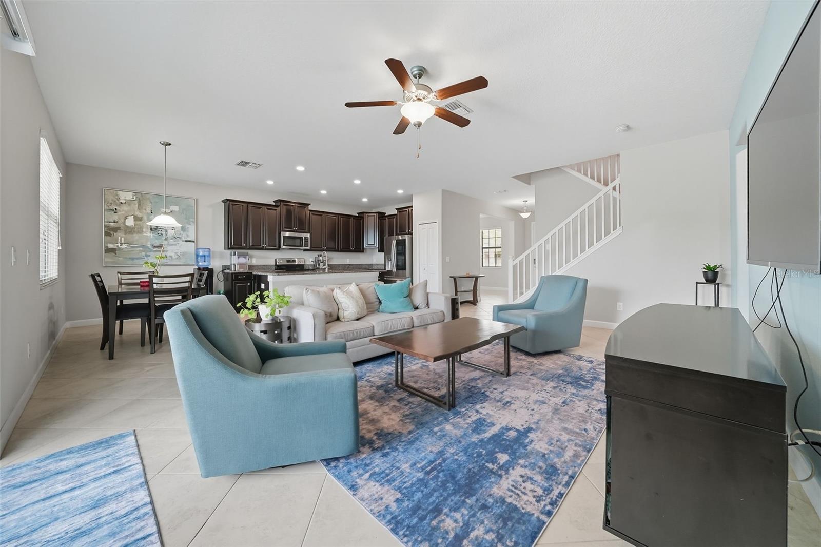 Spacious living room filled with natural light, seamlessly connected to the kitchen and dining areas. An open-concept design perfect for entertaining and everyday family living