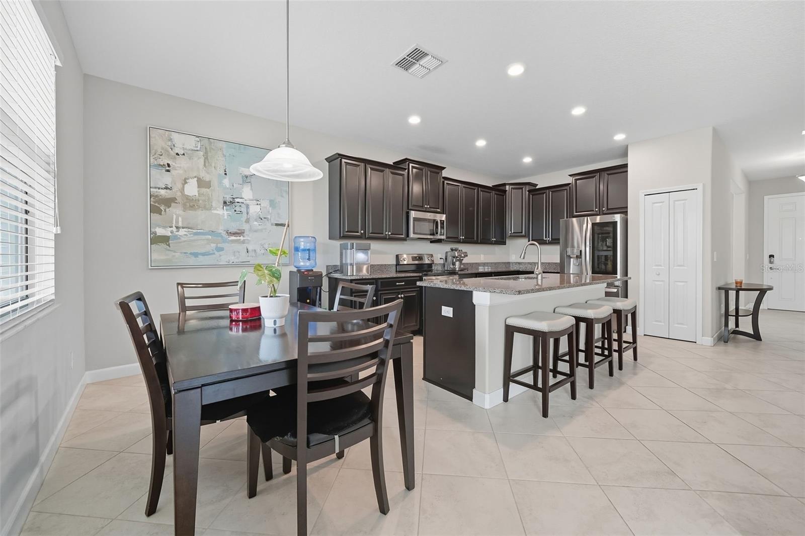 Cozy dining nook filled with natural light, perfectly positioned next to the kitchen. The oversized granite island with bar seating makes this space ideal for both casual meals and entertaining.