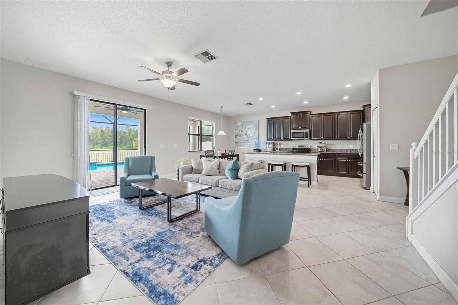 Spacious open-concept living with easy flow from the kitchen and dining areas to the screened pool and patio. Large sliding doors bring in natural light and highlight your private backyard oasis.