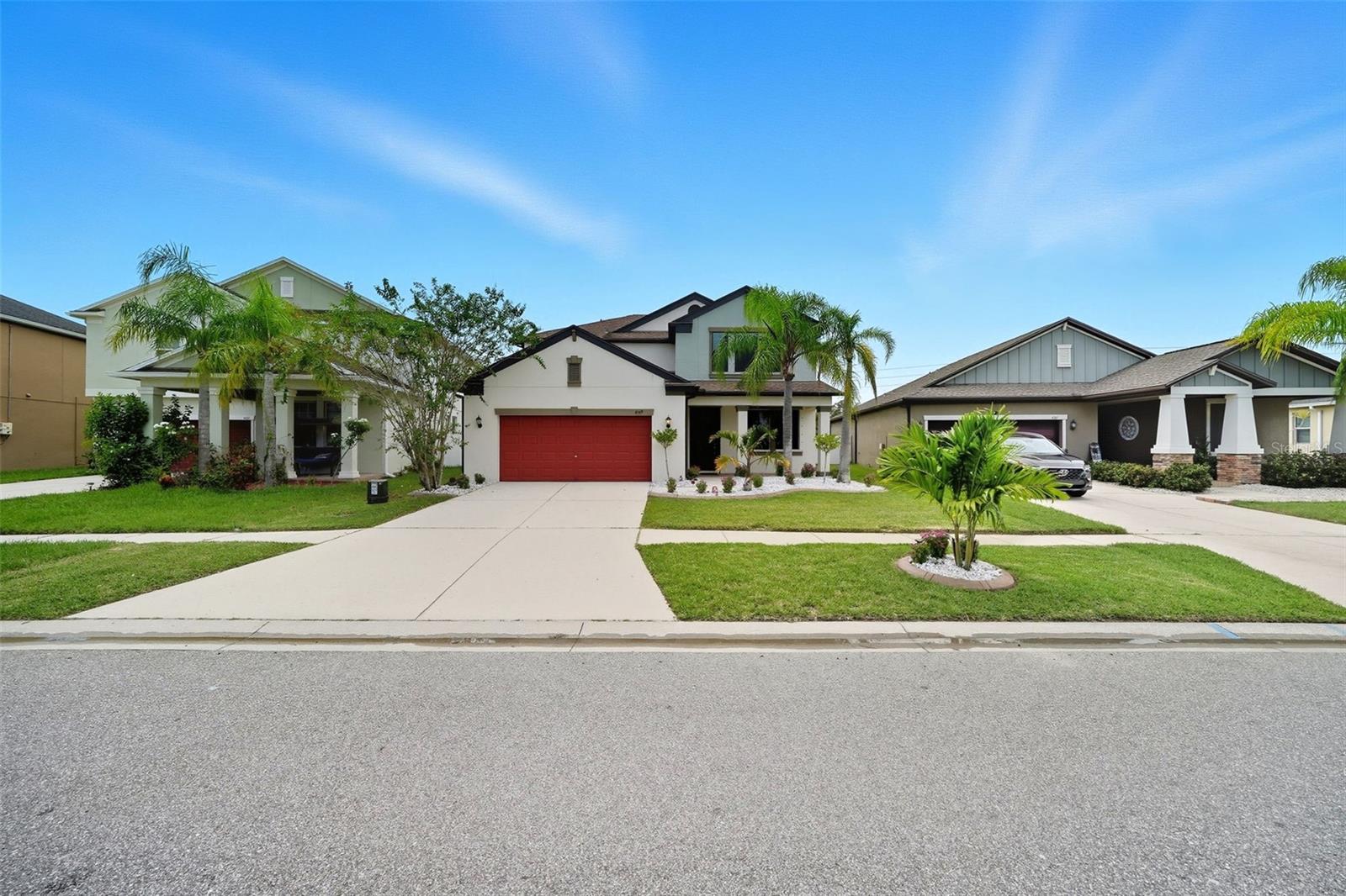 Beautiful curb appeal with fresh landscaping, a welcoming front porch, and a bold red garage door that makes this Concord Station home stand out