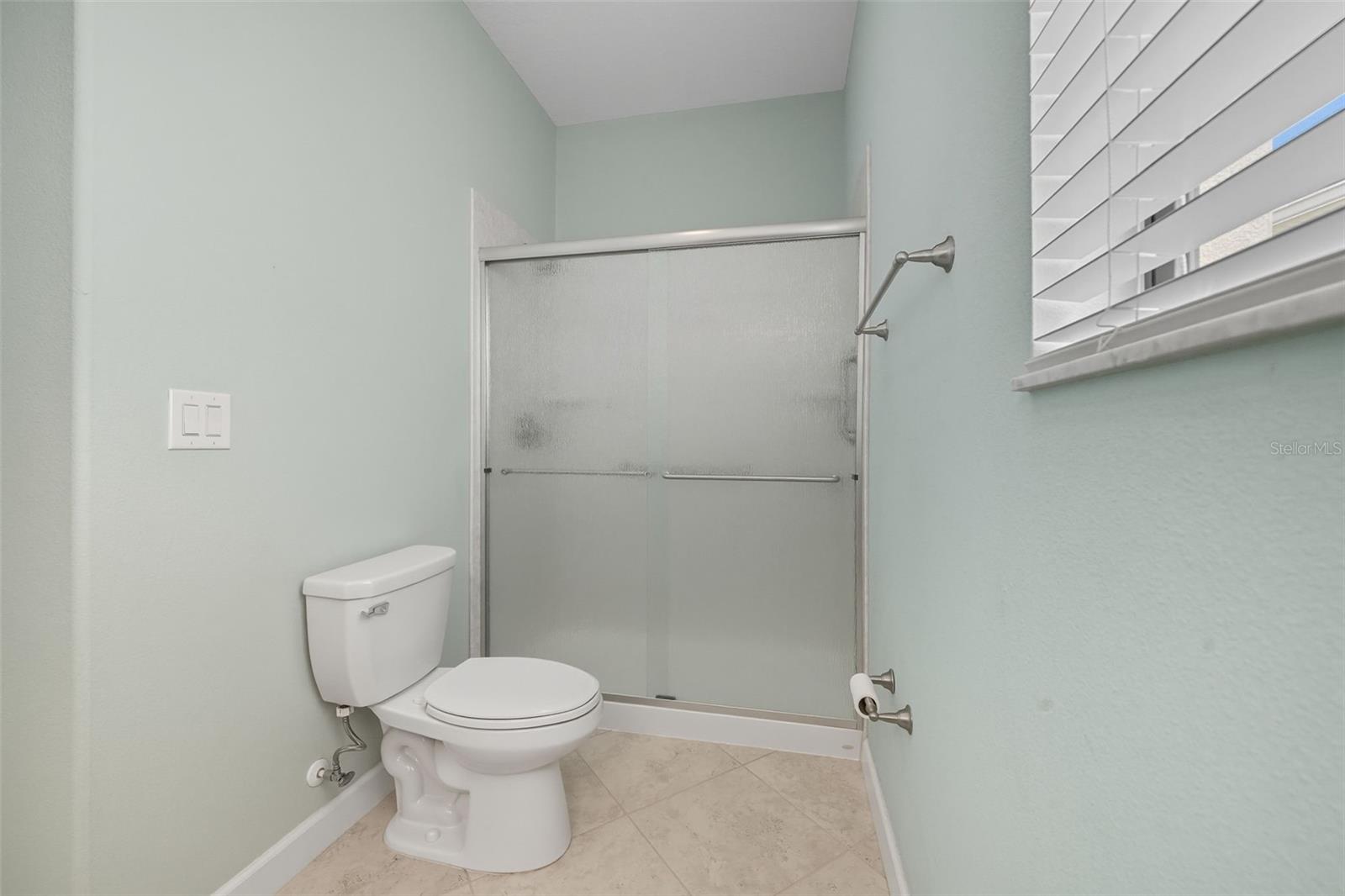 Convenient full bathroom located downstairs with walk-in shower—perfect for guests or poolside access.