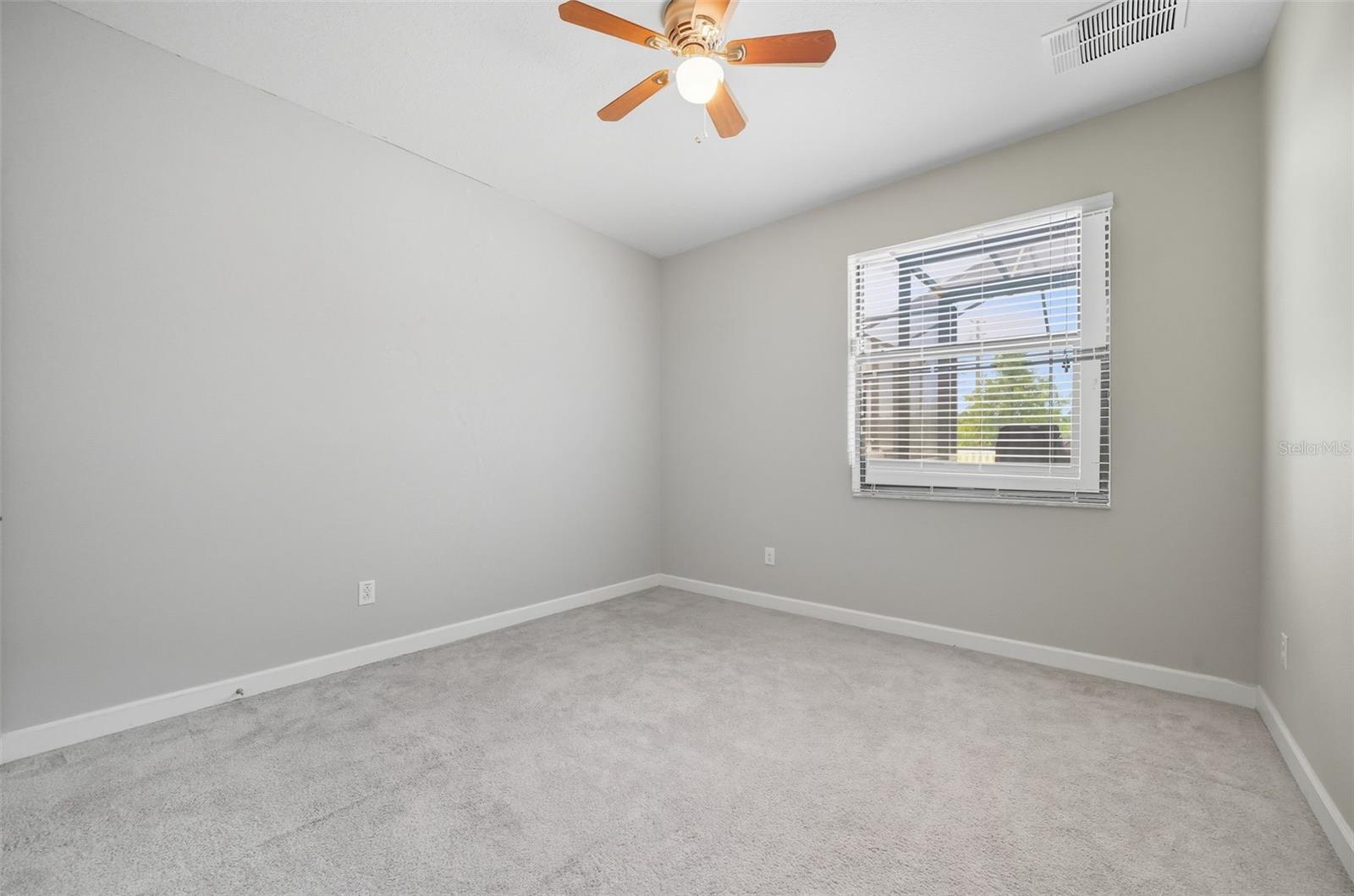 Downstairs bedroom overlooking the backyard—perfect as a guest room, private office, or flex space to fit your lifestyle