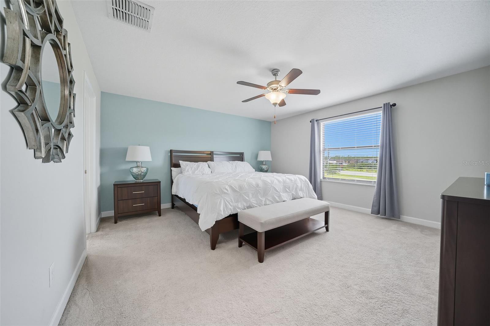 Expansive primary suite with plush carpeting, soothing color palette, and a large window bringing in natural light. A true retreat with plenty of room for a king bed and additional furnishings.