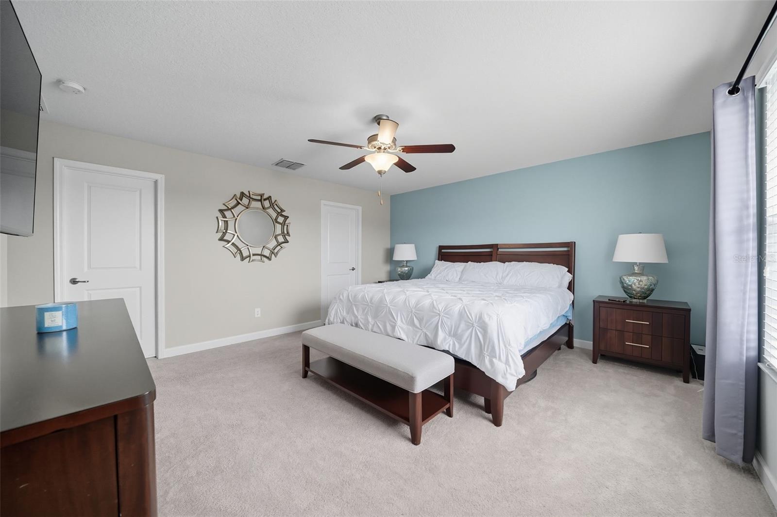 Retreat to your private primary bedroom with soft natural light, a soothing accent wall, and direct access to your ensuite bath and walk-in closet