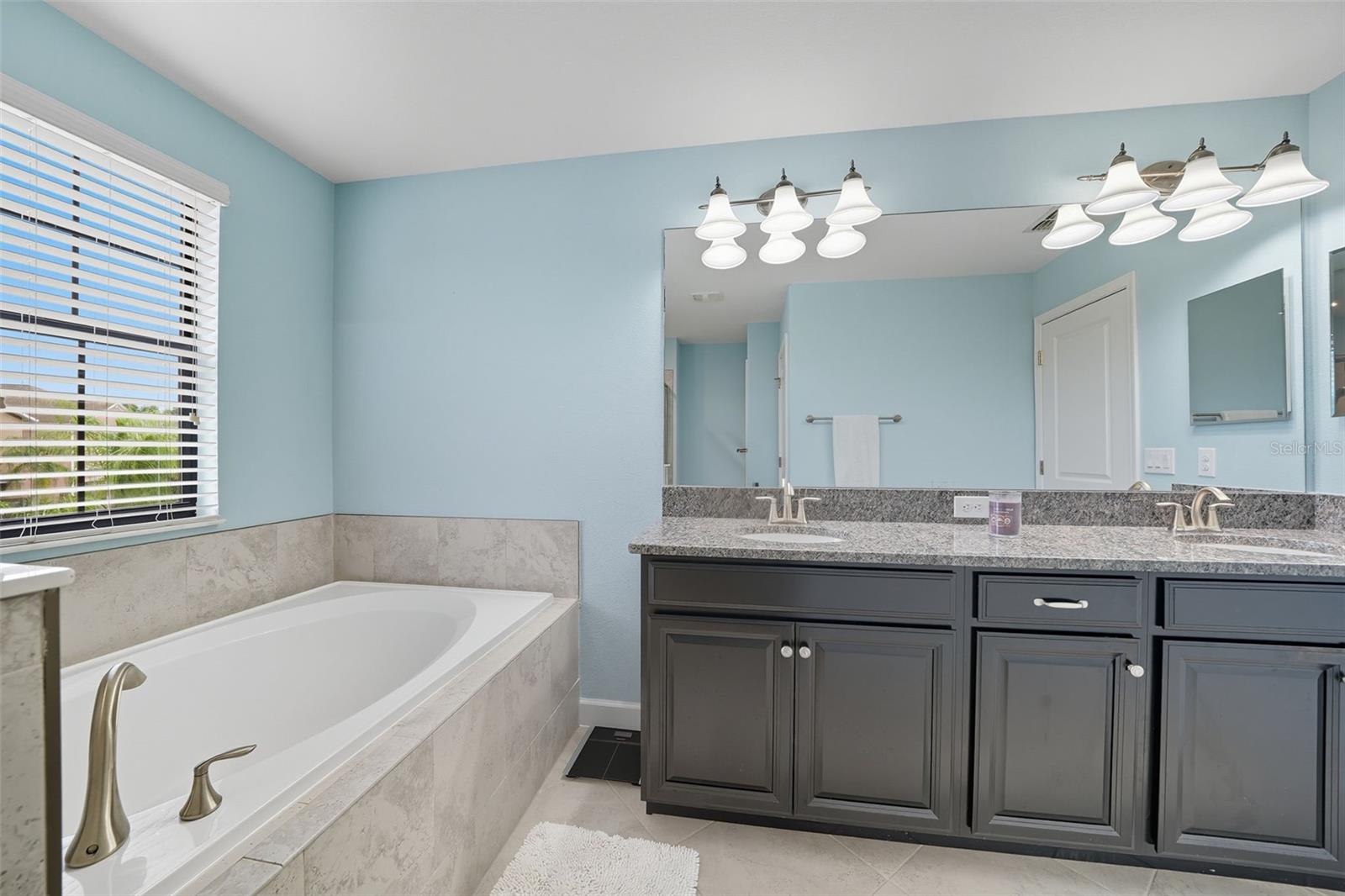 The primary ensuite features a dual vanity with granite countertops, offering plenty of space and style