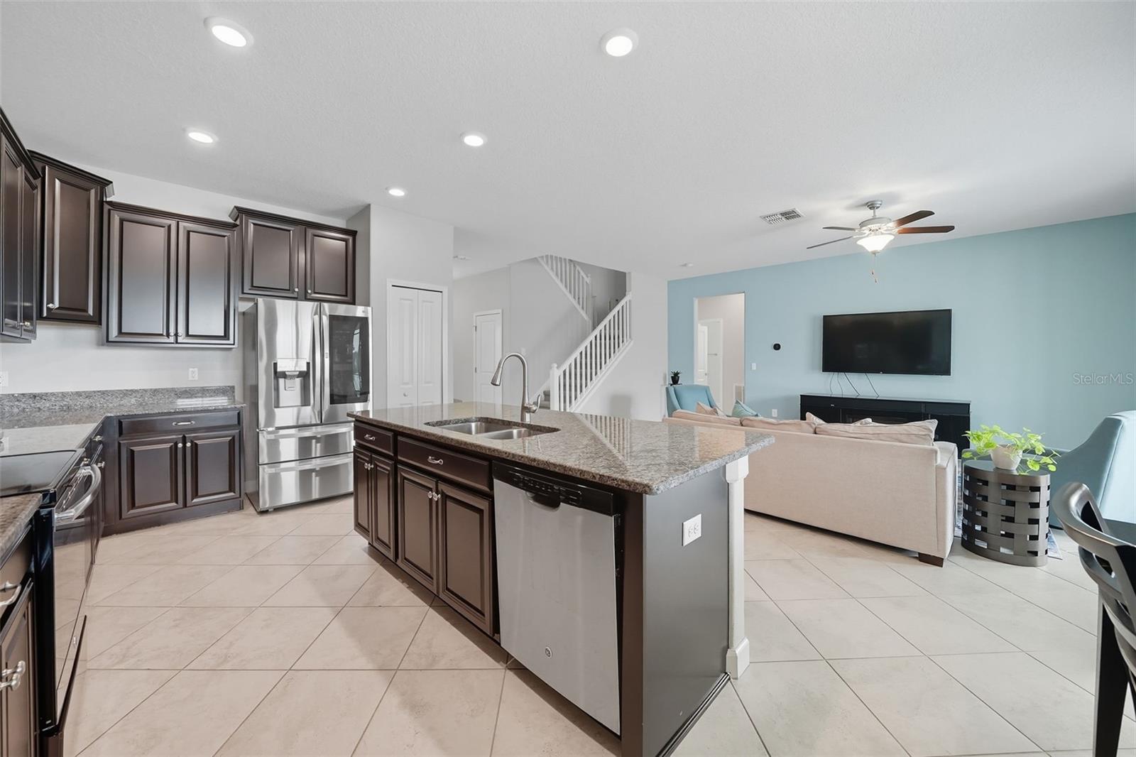 Expansive granite island with sink and plenty of room for barstools, creating the perfect spot for casual dining and entertaining while staying connected to the open living area