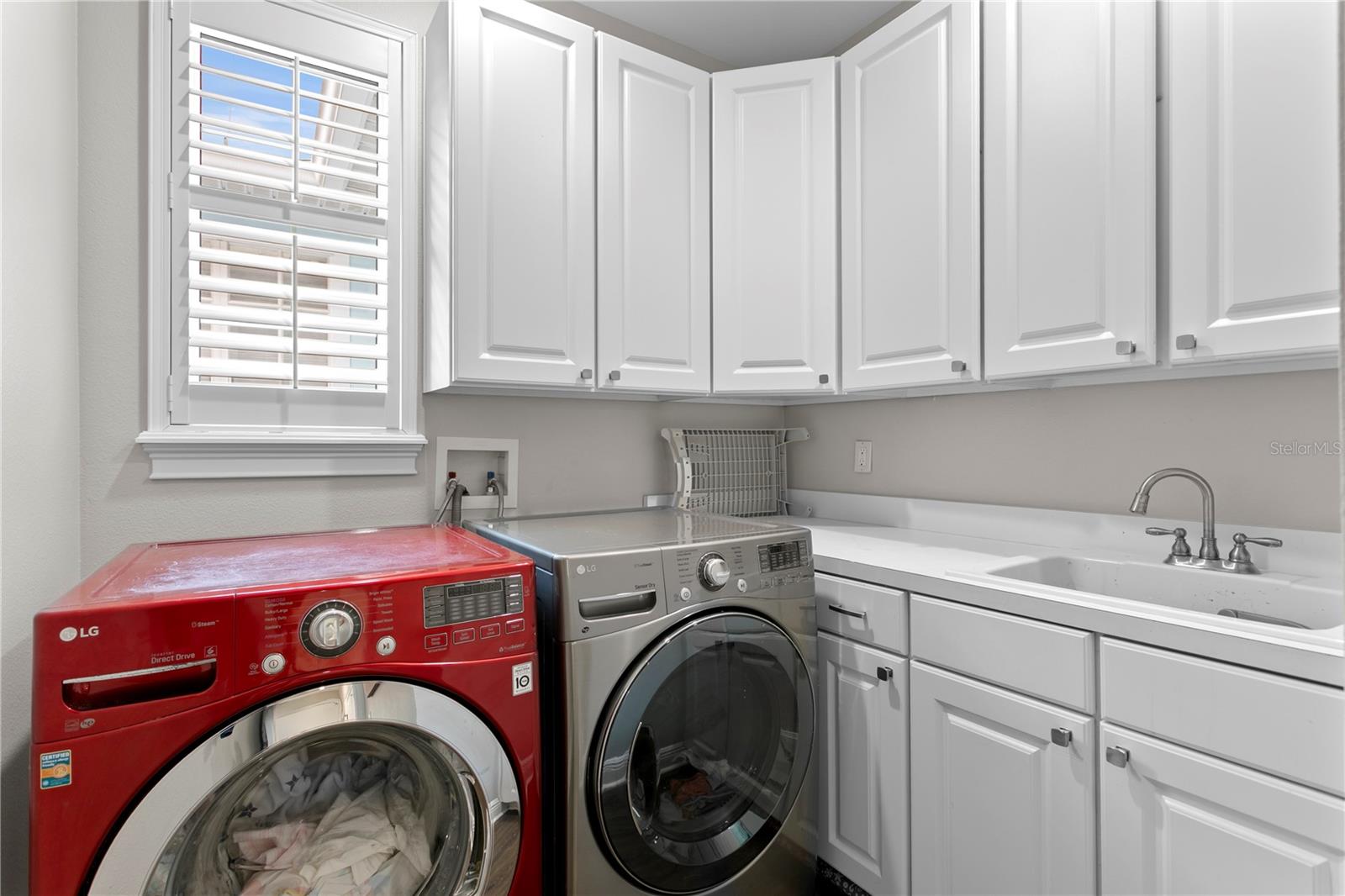 Full laundry ROOM with loads of storage and a utility sink