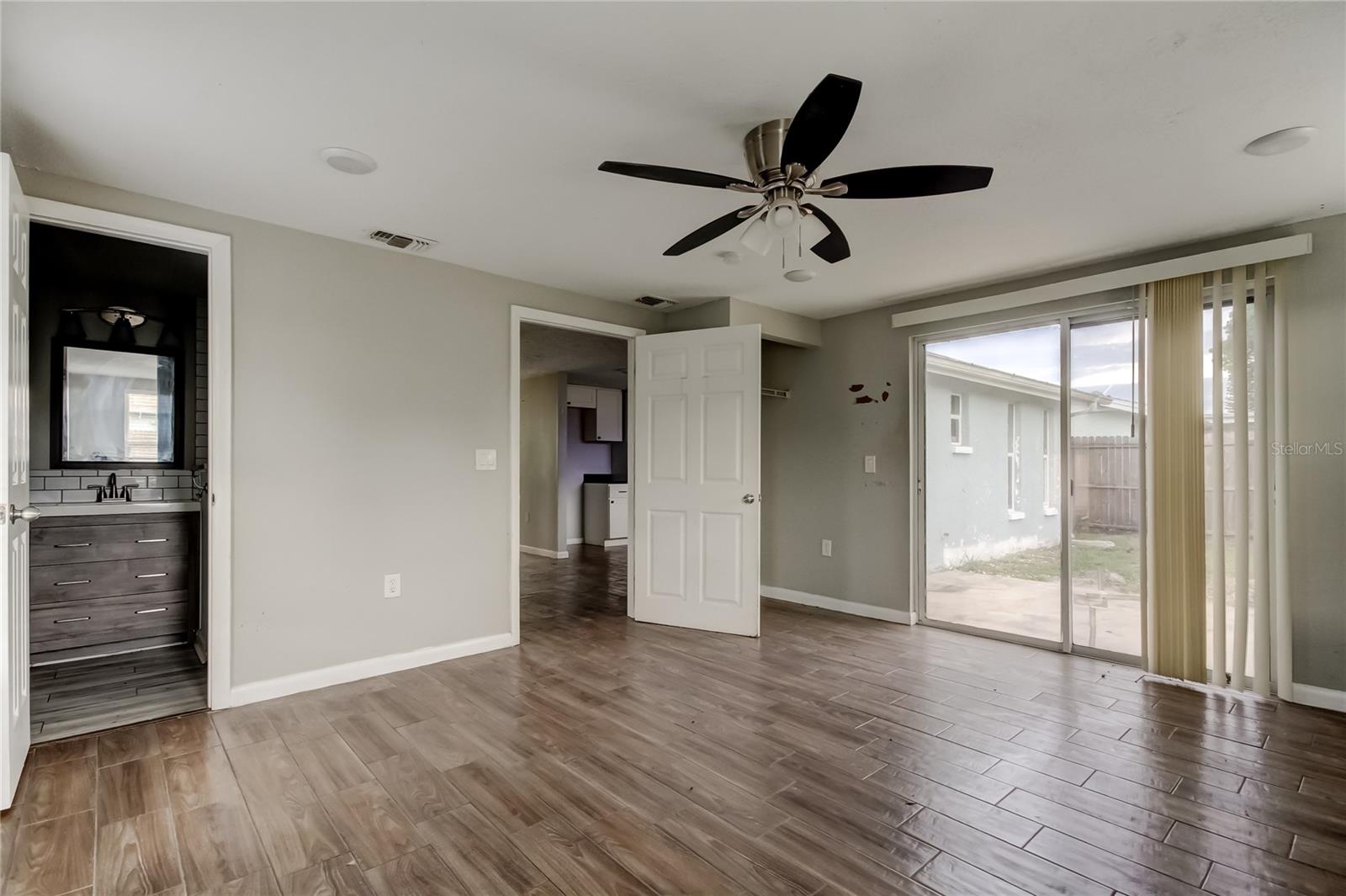 Primary BR with sliders leading to patio/backyard