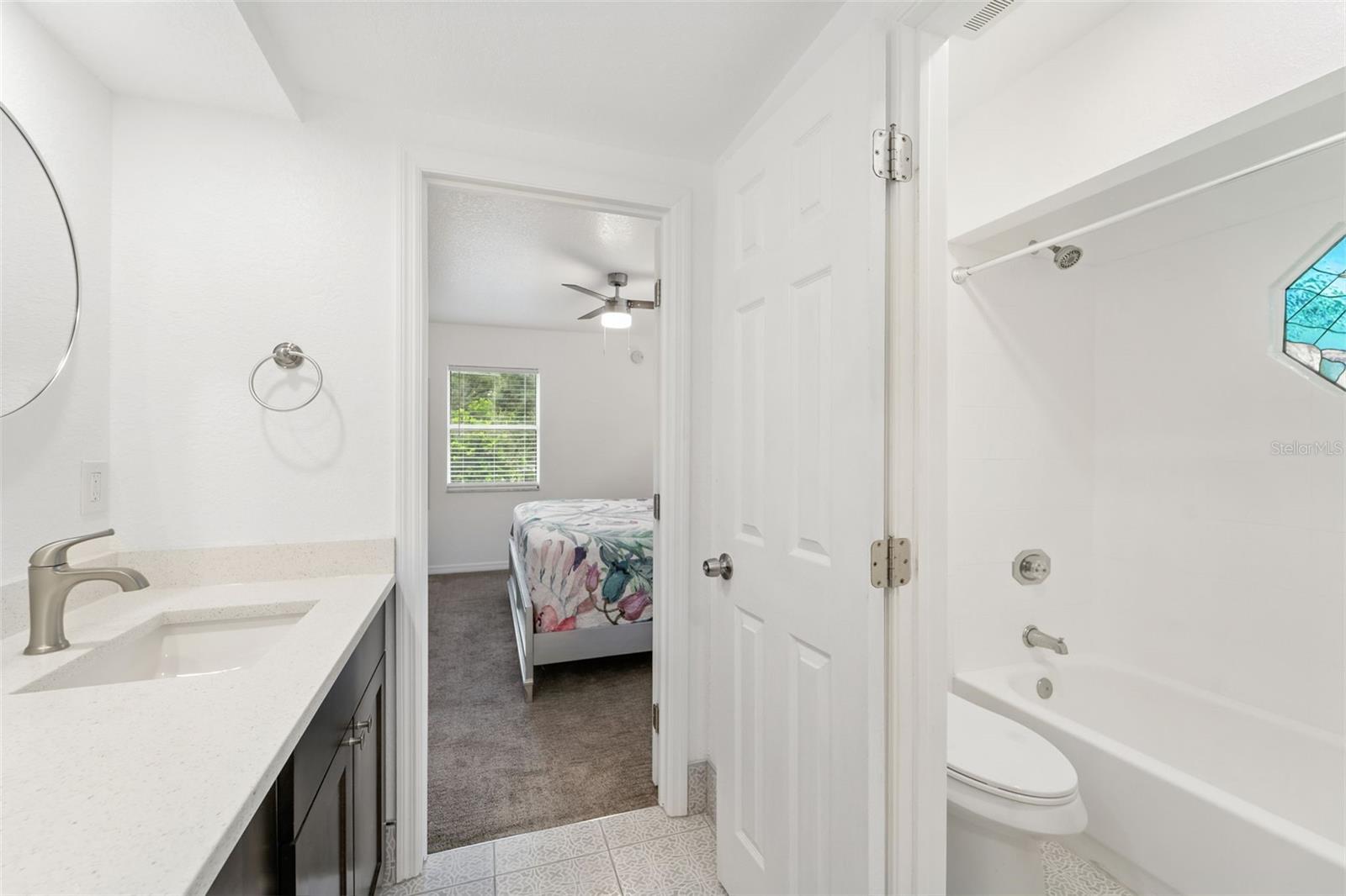 Jack-and-Jill Bathroom double sink vanity with quartz. Toilet and shower has its own door for privacy.