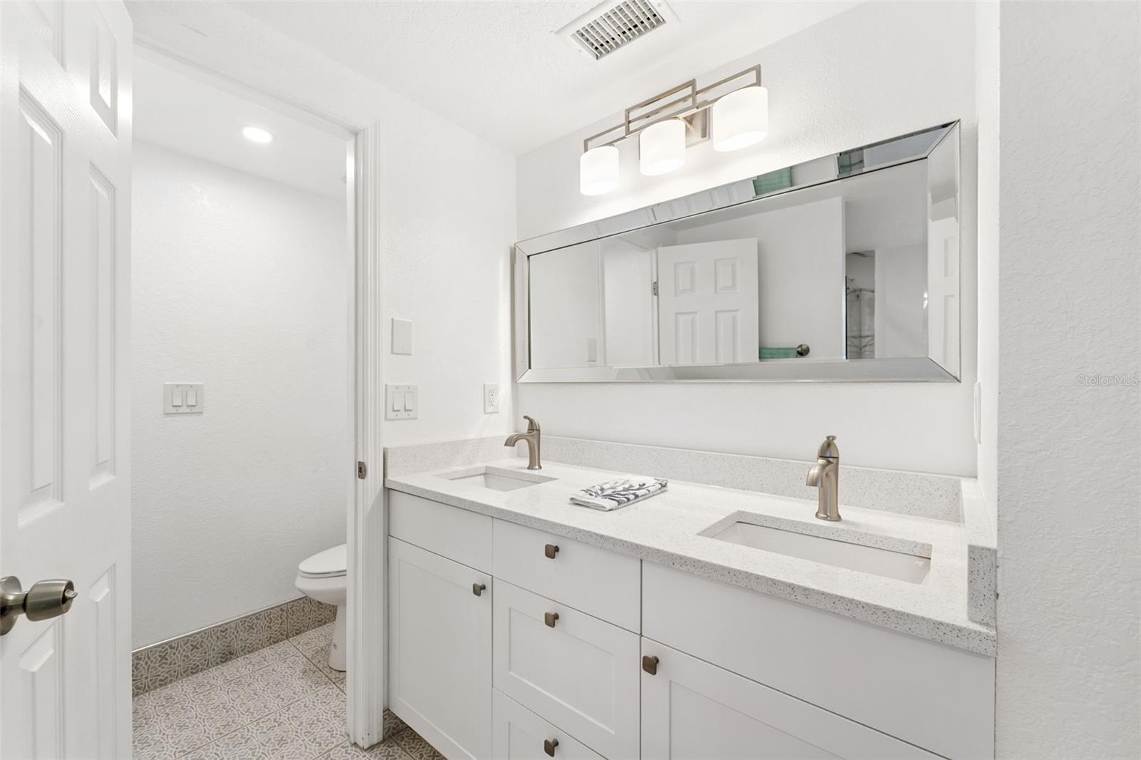 Oversized double vanity with quartz and natural light perfect for getting ready to go out.