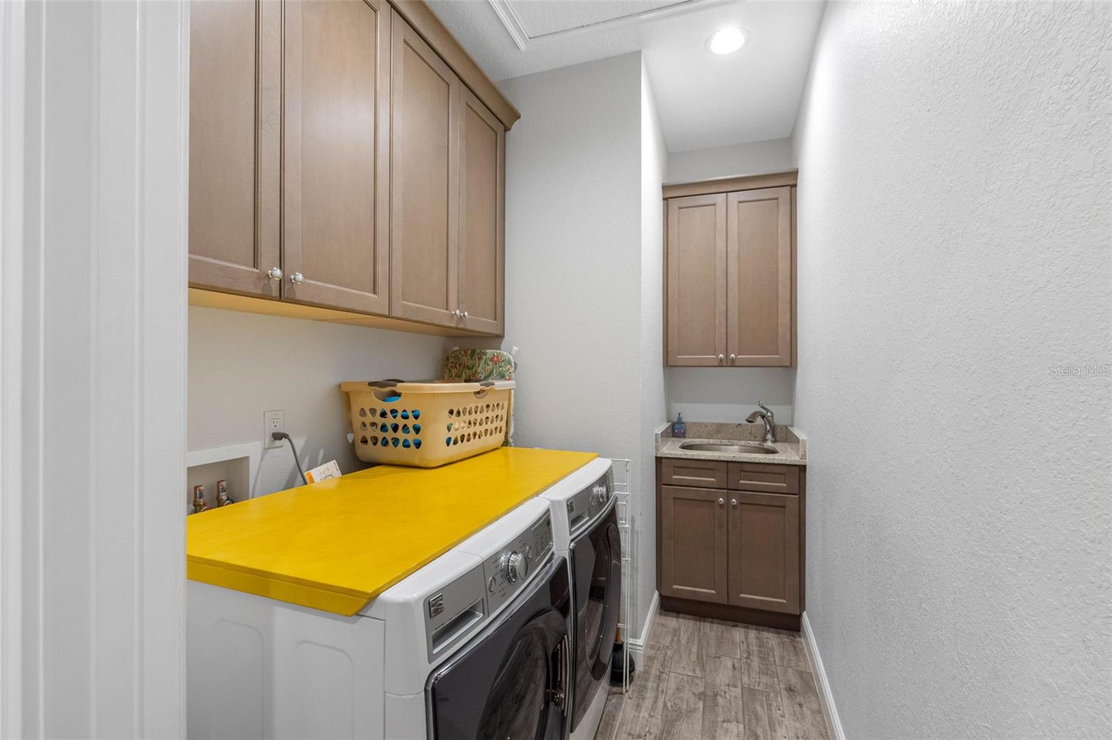 Interior laundry room with a sink and nice cabinetry