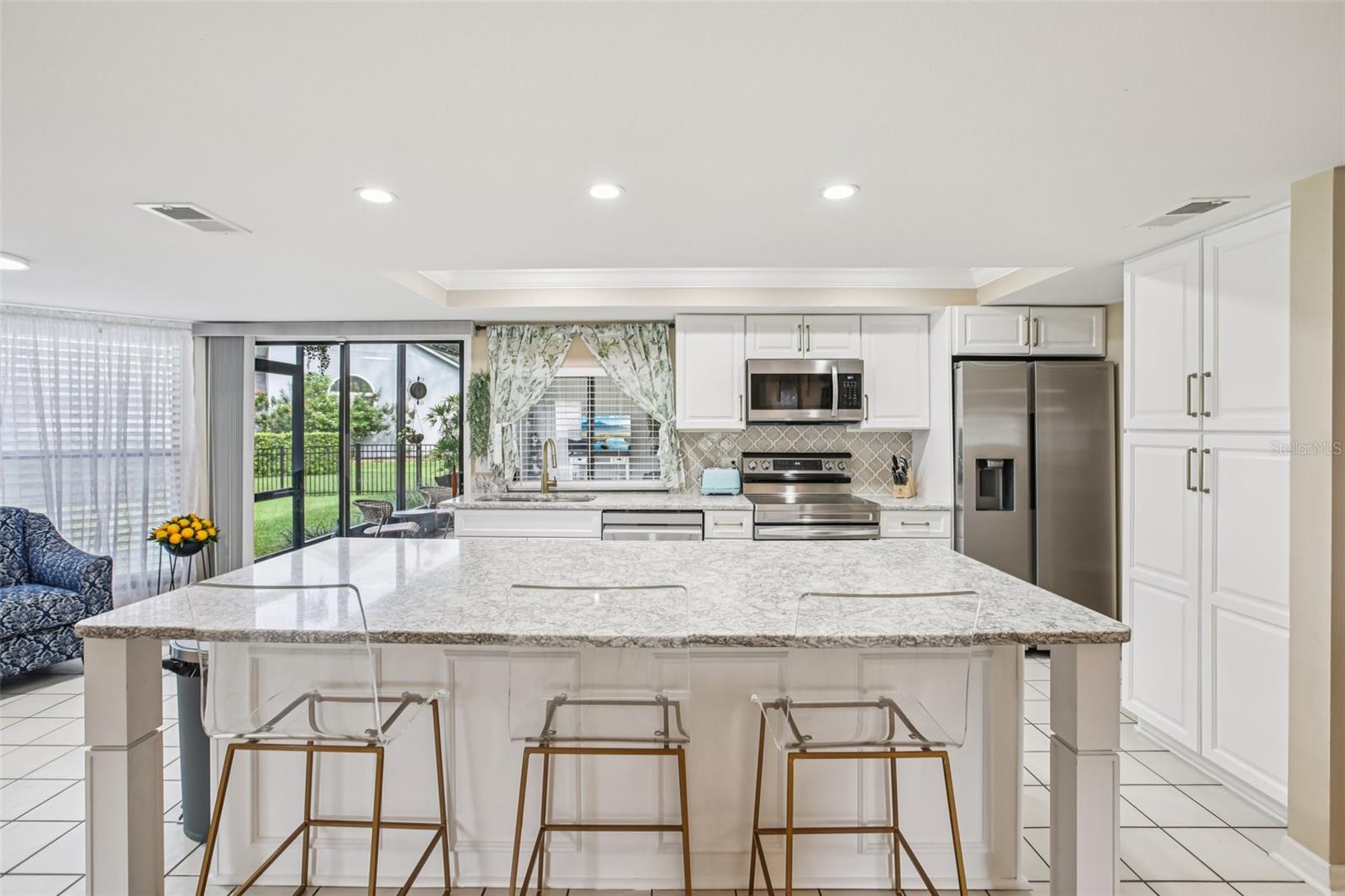 Beautifully renovated open kitchen with quarts countertops, center island,  soft close cabinets, new appliances, overhead lighting and beautiful back splash.  Sliders open to Lanai