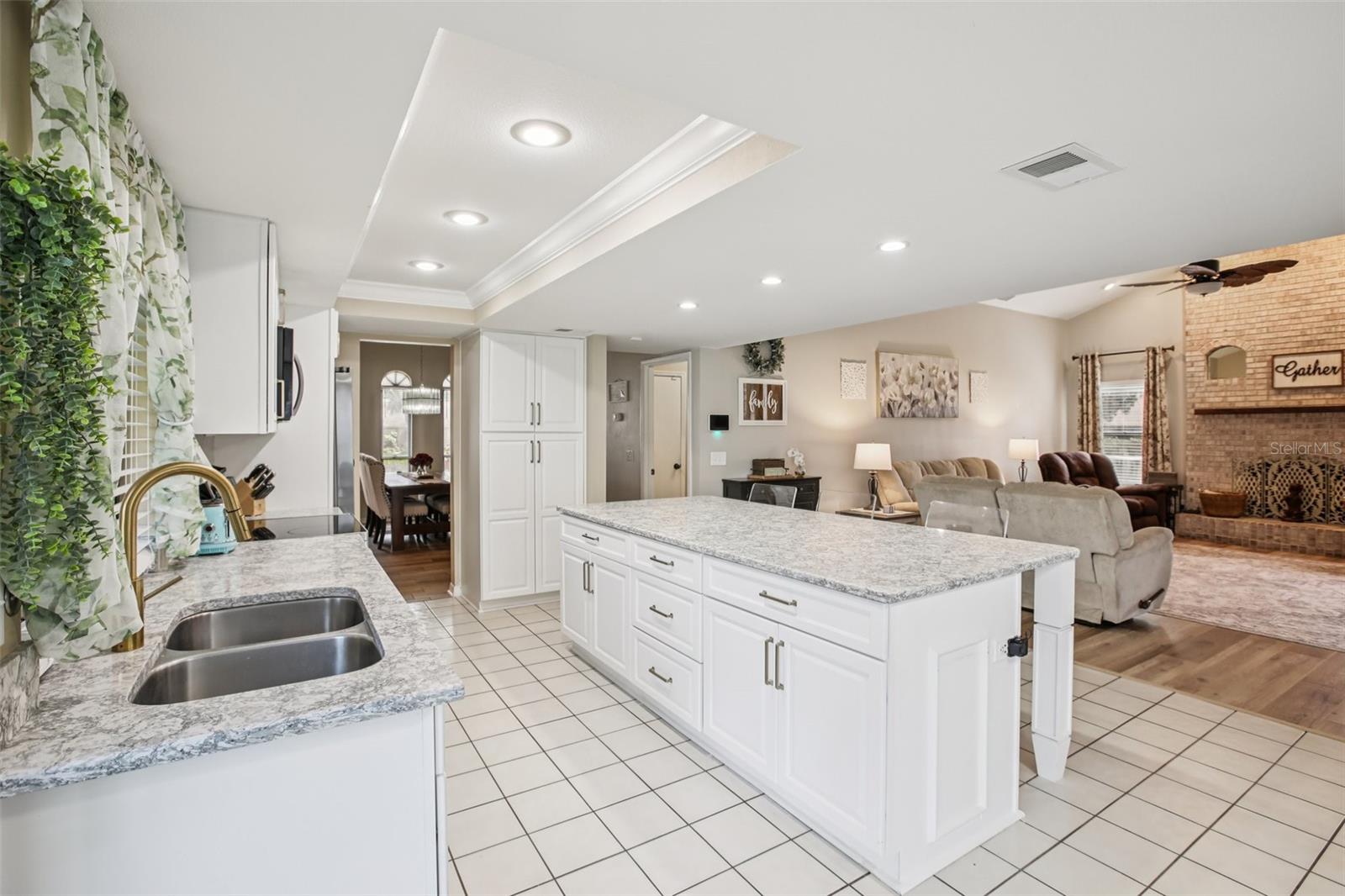 Beautifully renovated open kitchen with quarts countertops, center island,  soft close cabinets, new appliances, overhead lighting and beautiful back splash.  Kitchen opens to family room