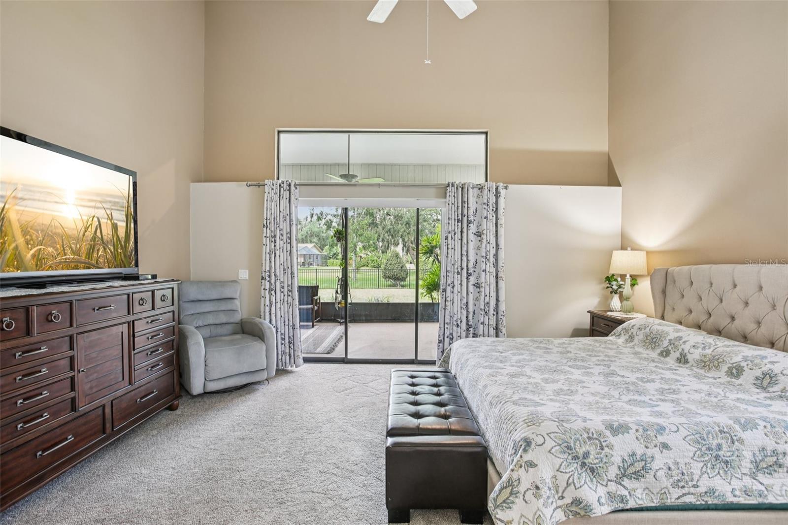 Primary bedroom with sliders to the lanai and beautiful back yard