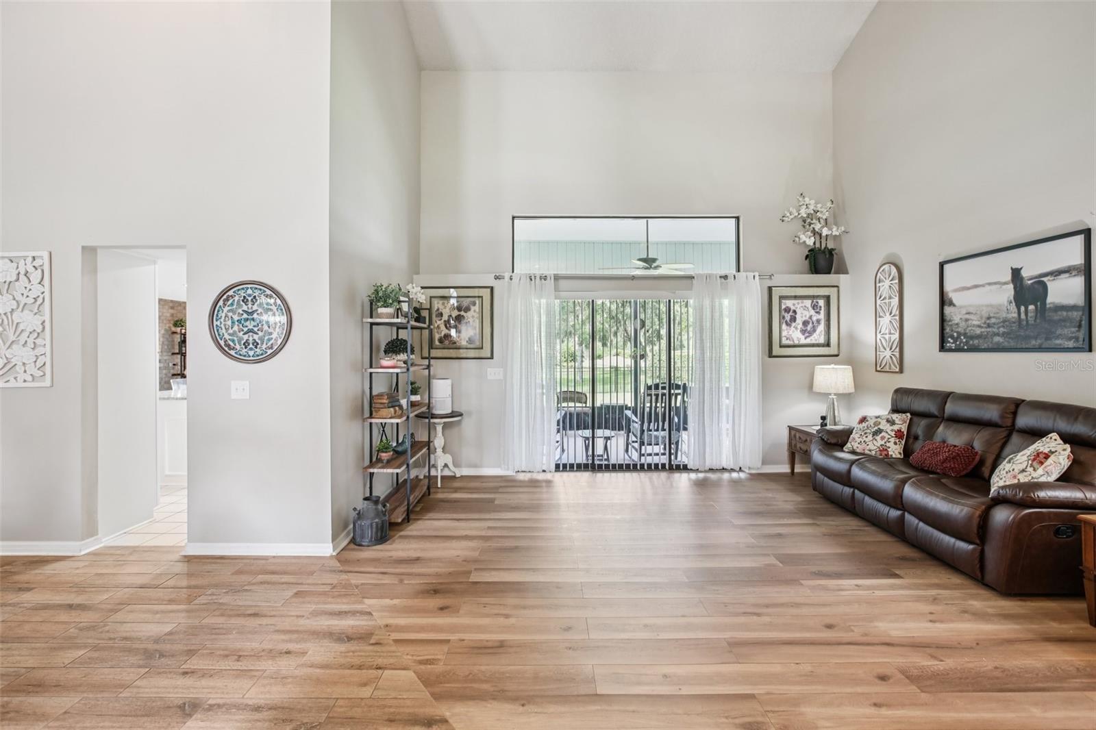 Living Room with high ceilings, sliders to the lanai and beautiful luxury vinyl plank floors