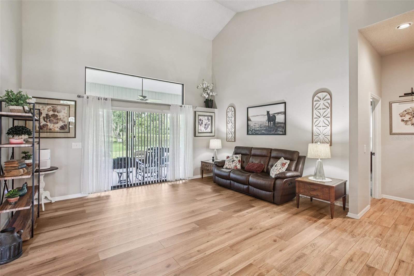 Living Room with high ceilings, sliders to the lanai and beautiful luxury vinyl plank floor