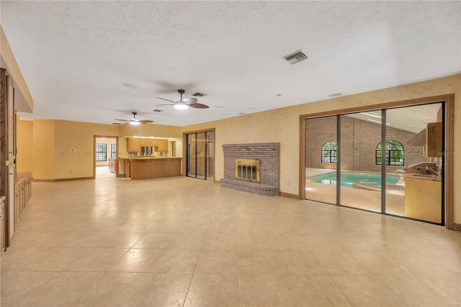 The Family room opens to the 2-story atrium with pool & spa and is adjacent to the kitchen.