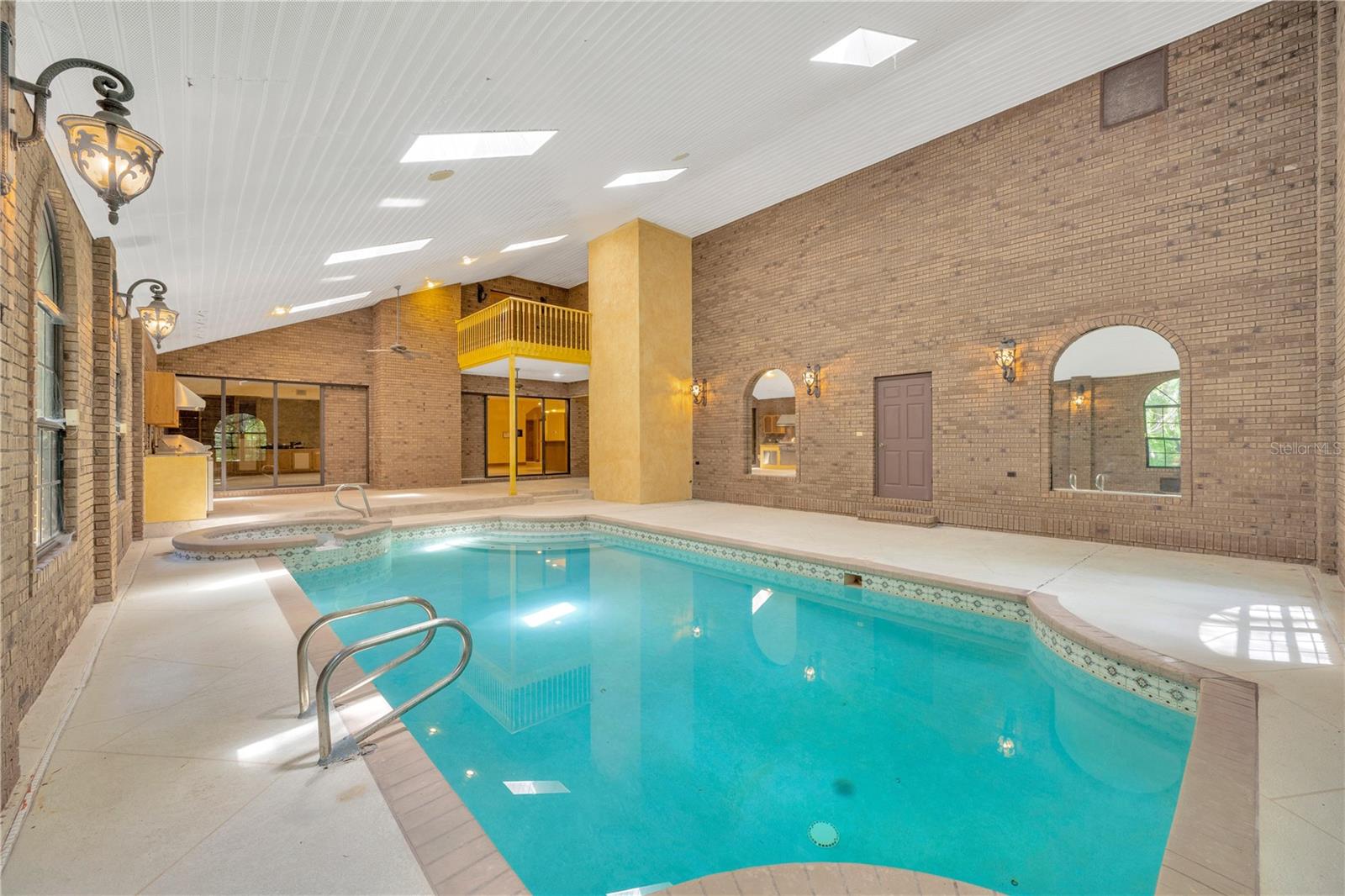 This indoor oasis is set under a two-story vaulted ceiling with skylights.  Ascend by elevator to the 2nd floor balcony just outside of the Owner's Suite and flex room with its own fireplace.