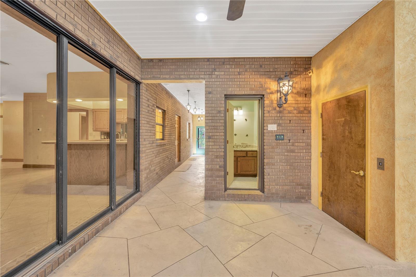 The Inside Atrium has access to a full bathroom with a shower making this area ideal for year-round entertaining.The hallway ahead leads to the side door entrance next to the garages.