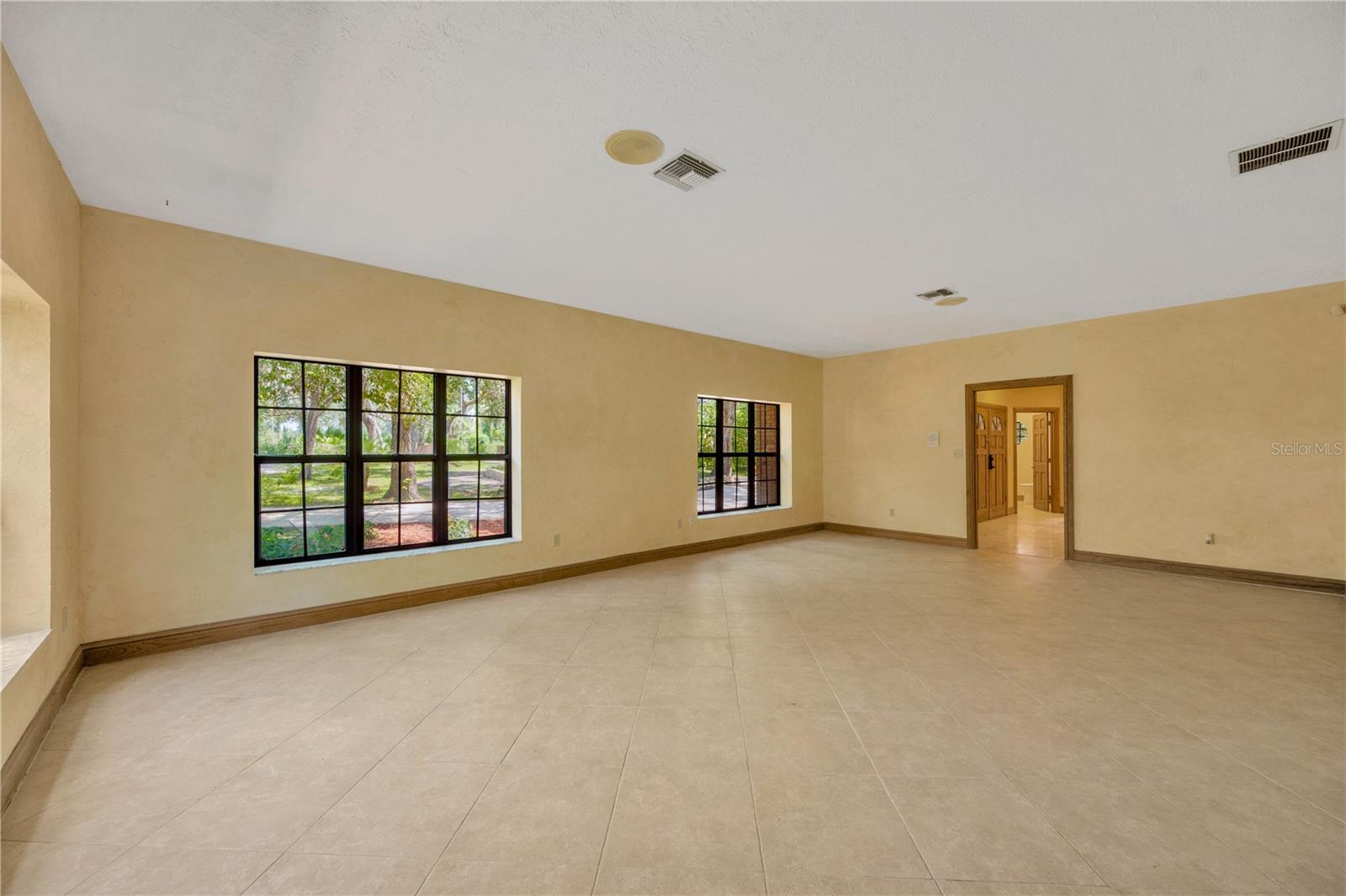 The living room offers tranquil views of the manicured, gated entry