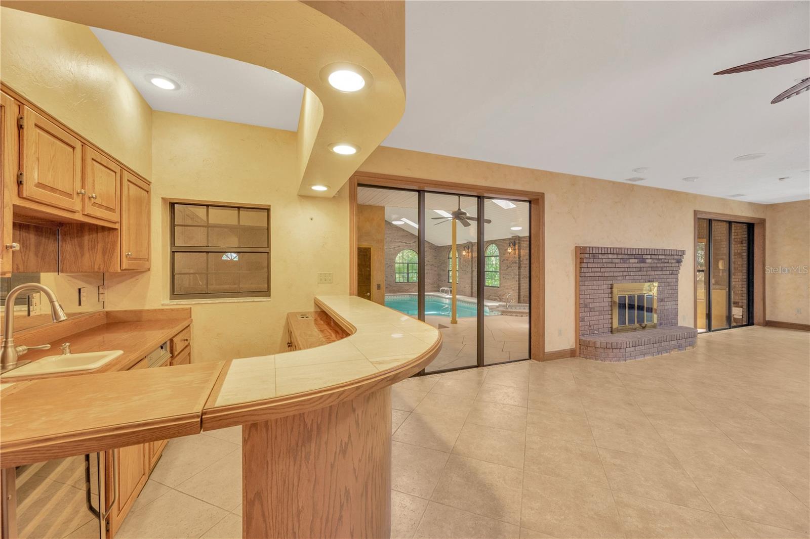 Family room with fireplace and wet bar with ice maker, sink, frig, & built in counter top blender.