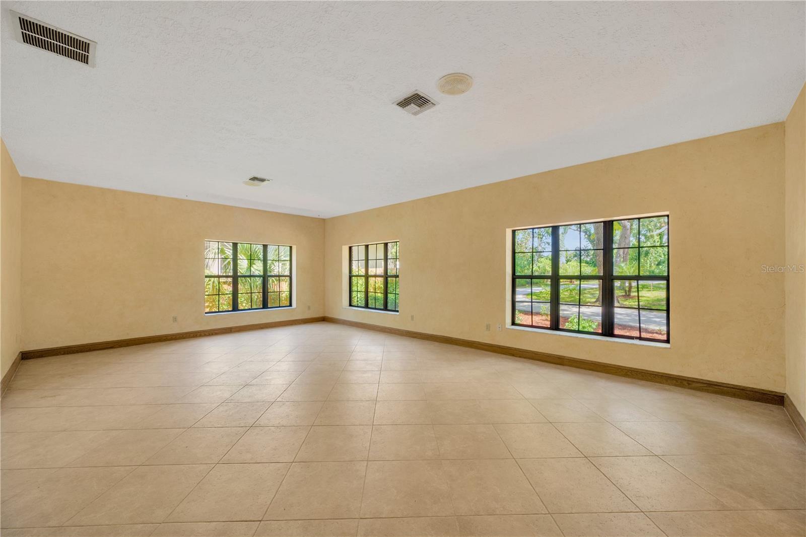 Living Room is spacious and framed by grand windows that flood the space with natural light.