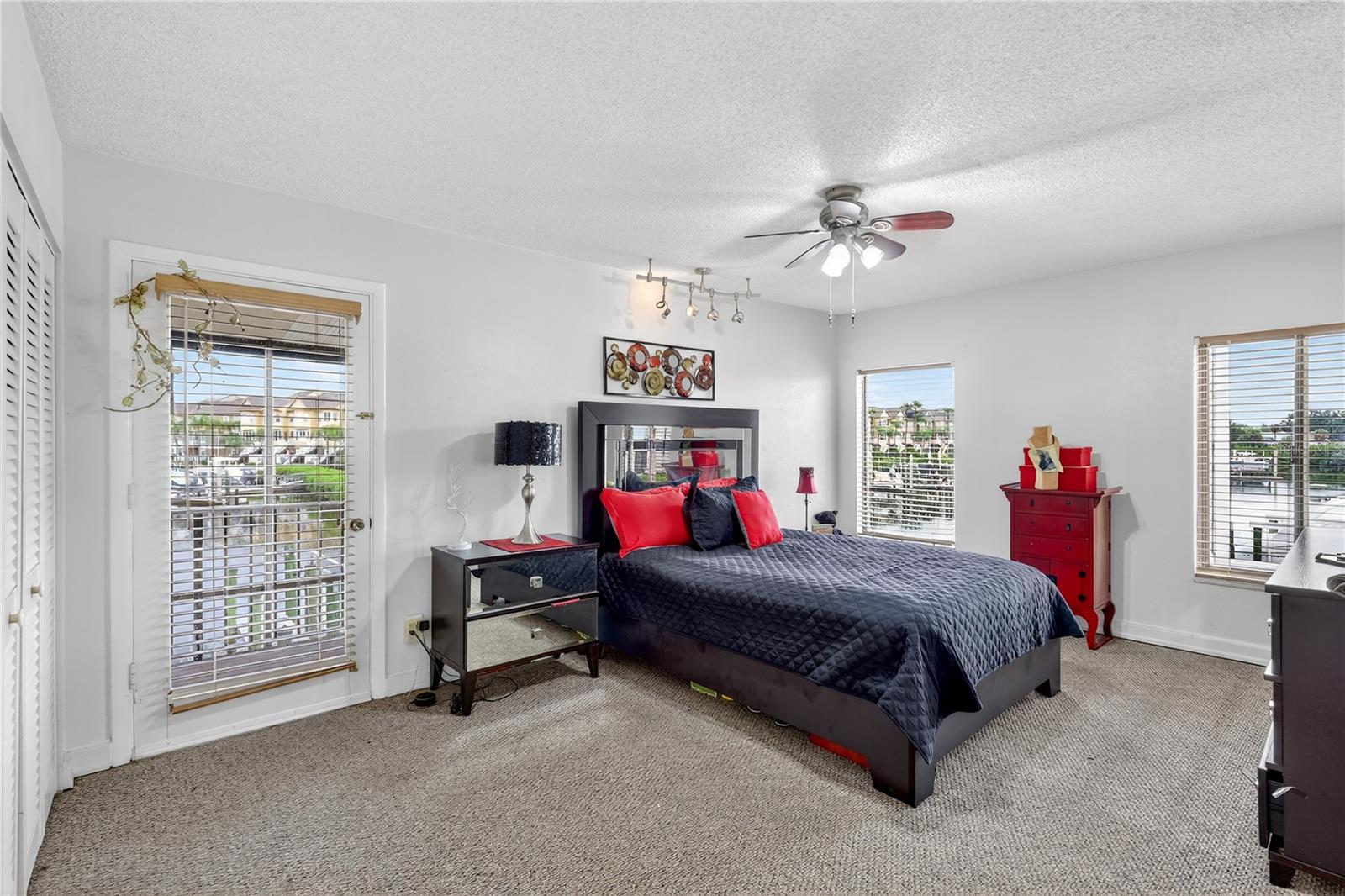 Large master bedroom features a door leading out to a screened balcony.