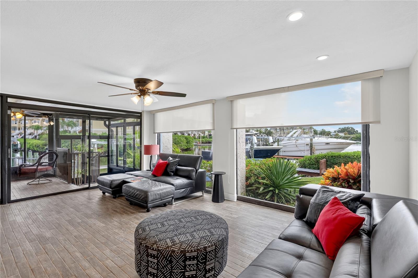Huge family room with two walls of windows overlooking water.