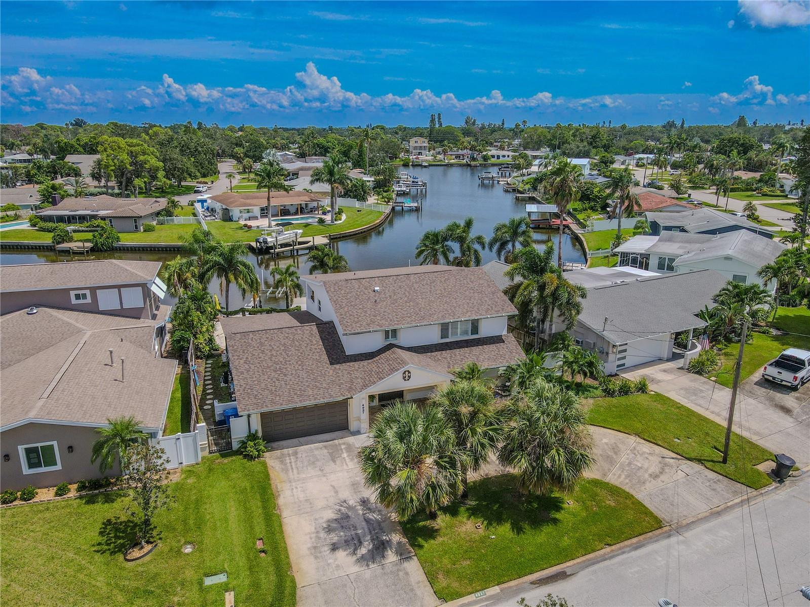 This two-story waterfront home offers classic curb appeal with a clean, coastal feelwith a welcoming covered entry. The wide circular driveway and attached two-car garage provide ample parking. Mature palms and tropical landscaping frame the front lawn, creating a lush, Florida-style setting.
