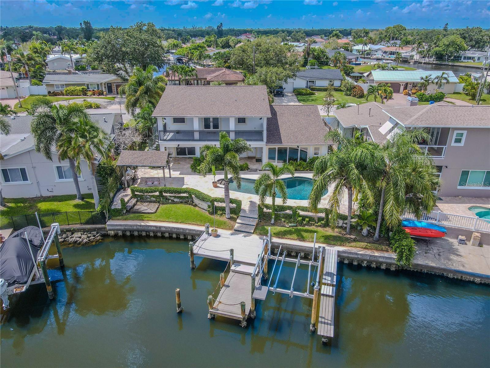 From the water, the backyard makes an impressive statement with its resort-style design. A private dock extends onto the canal, complete with a boat lift and additional platform for kayaks, paddleboards, or fishing.