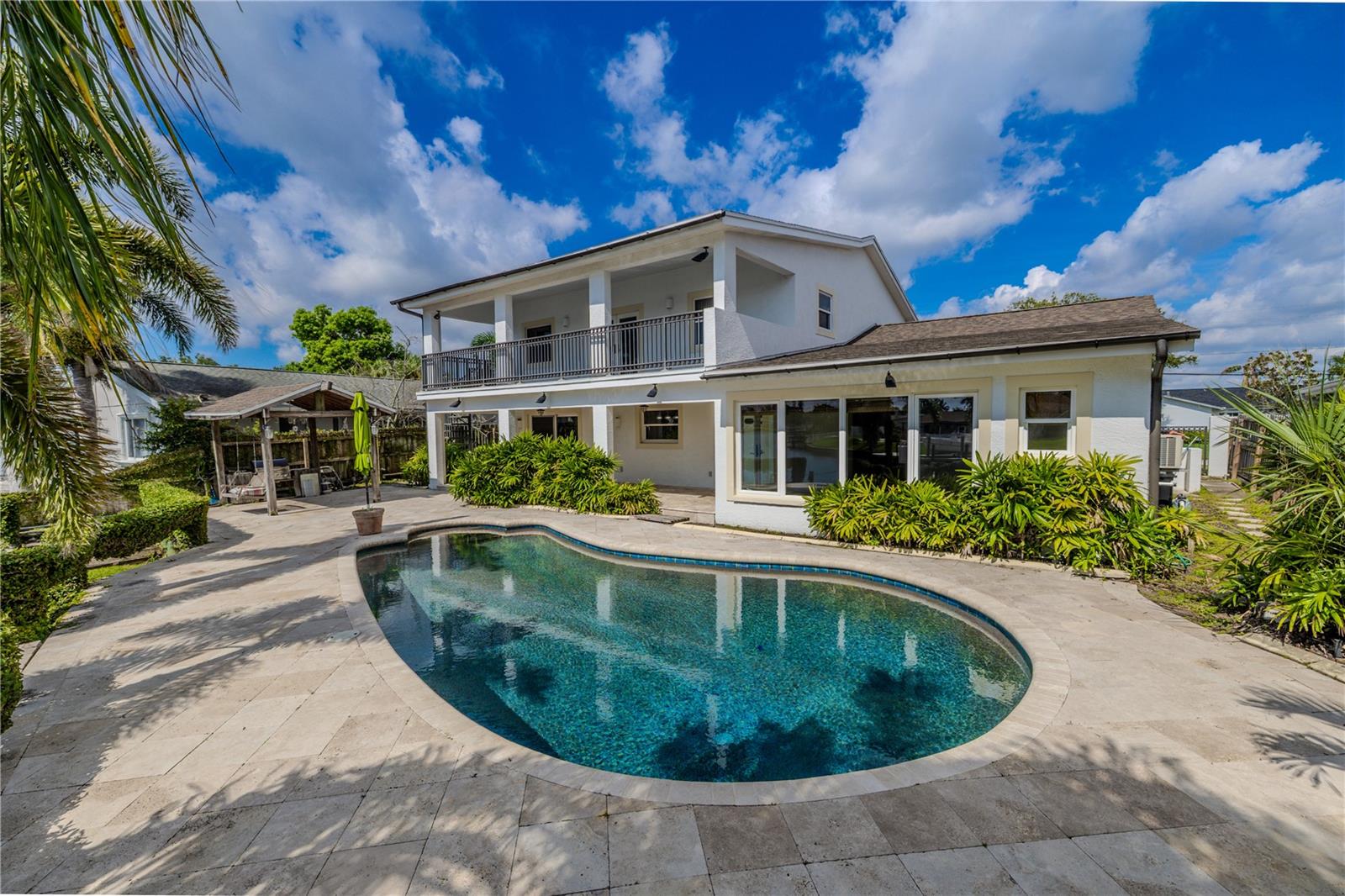 The home features a spacious 330 sq. ft. second-floor balcony, offering both indoor and outdoor access for versatile living. With room for lounging or dining, it’s the perfect spot to take in sweeping views of the pool, tropical landscaping, and canal. A spiral staircase provides convenient access between the balcony and backyard, blending functionality with resort-style appeal.