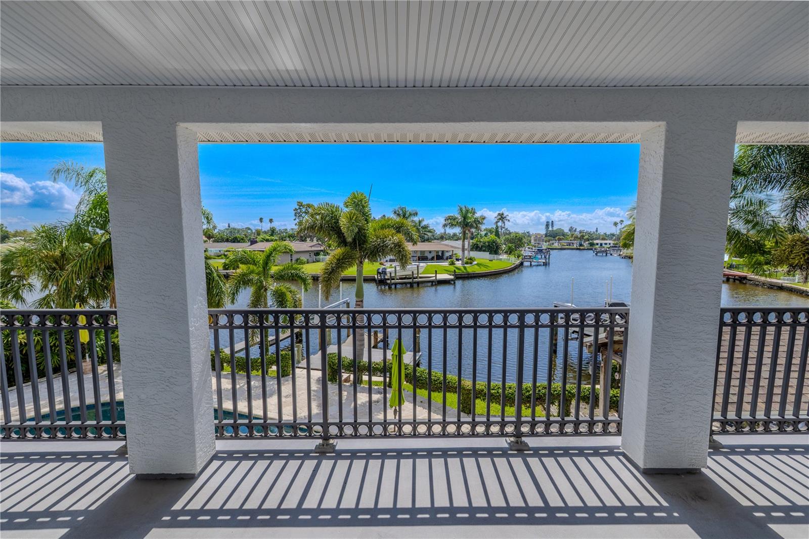The expansive 330 sq. ft. covered balcony off the primary suite offers breathtaking panoramic views of the wide canal.
