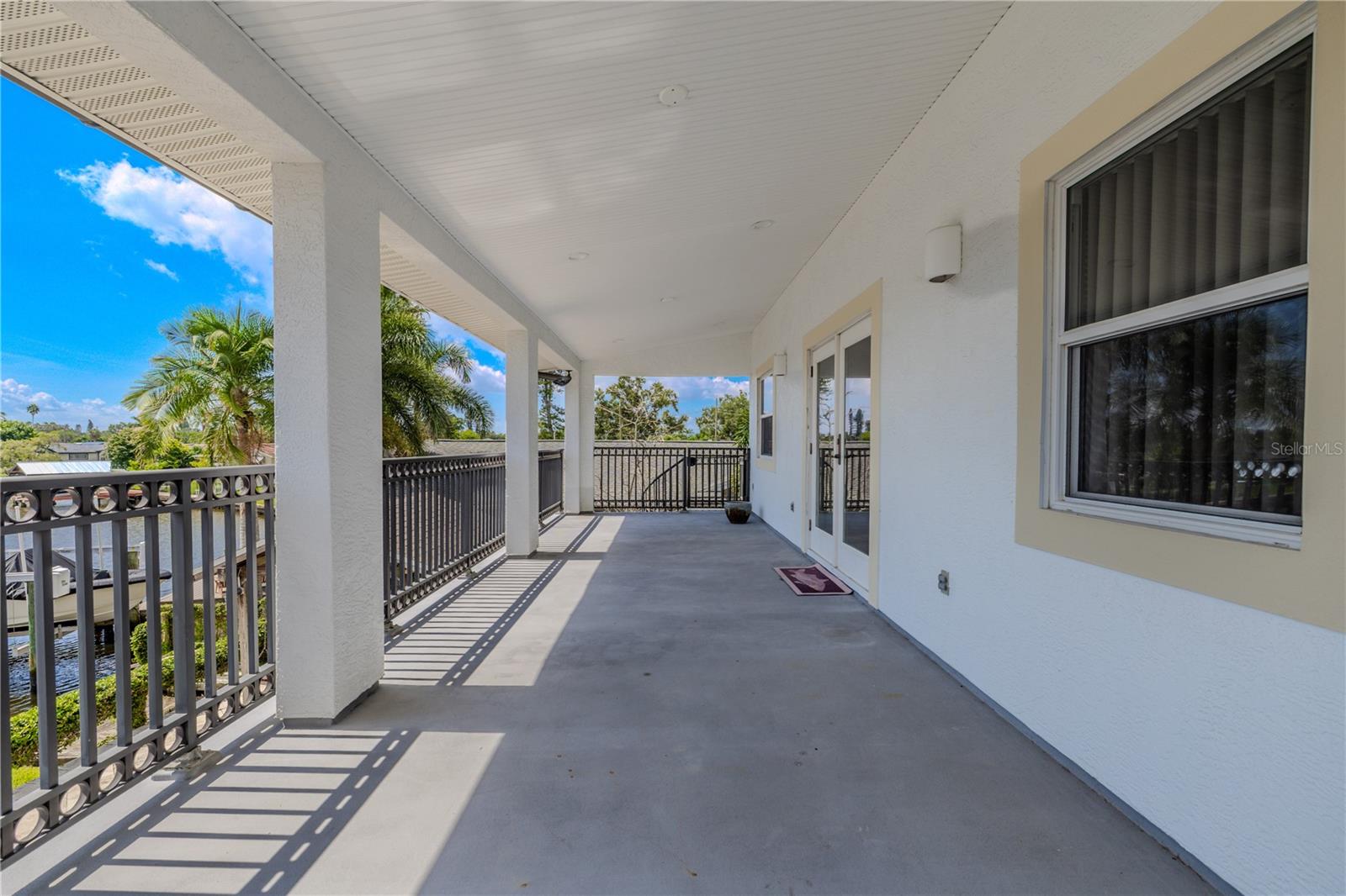 The expansive 330 sq. ft. covered balcony off the primary suite offers breathtaking panoramic views of the wide canal.