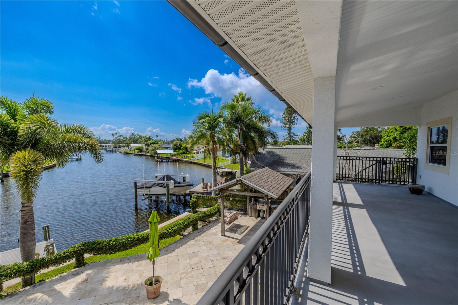 The expansive 330 sq. ft. covered balcony off the primary suite offers breathtaking panoramic views of the wide canal.