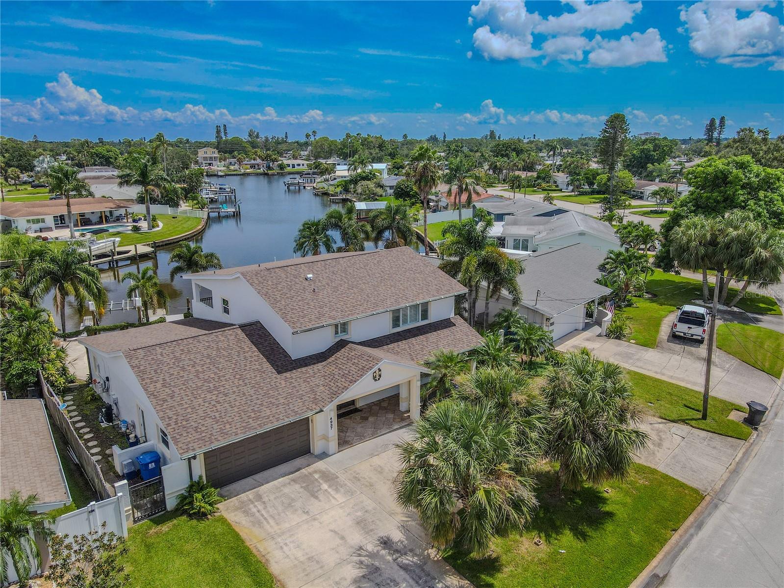 This waterfront home features a clean-lined Contemporary design with coastal influences, highlighted by open balconies, large windows, and functional indoor-outdoor living spaces that maximize canal views and natural light.