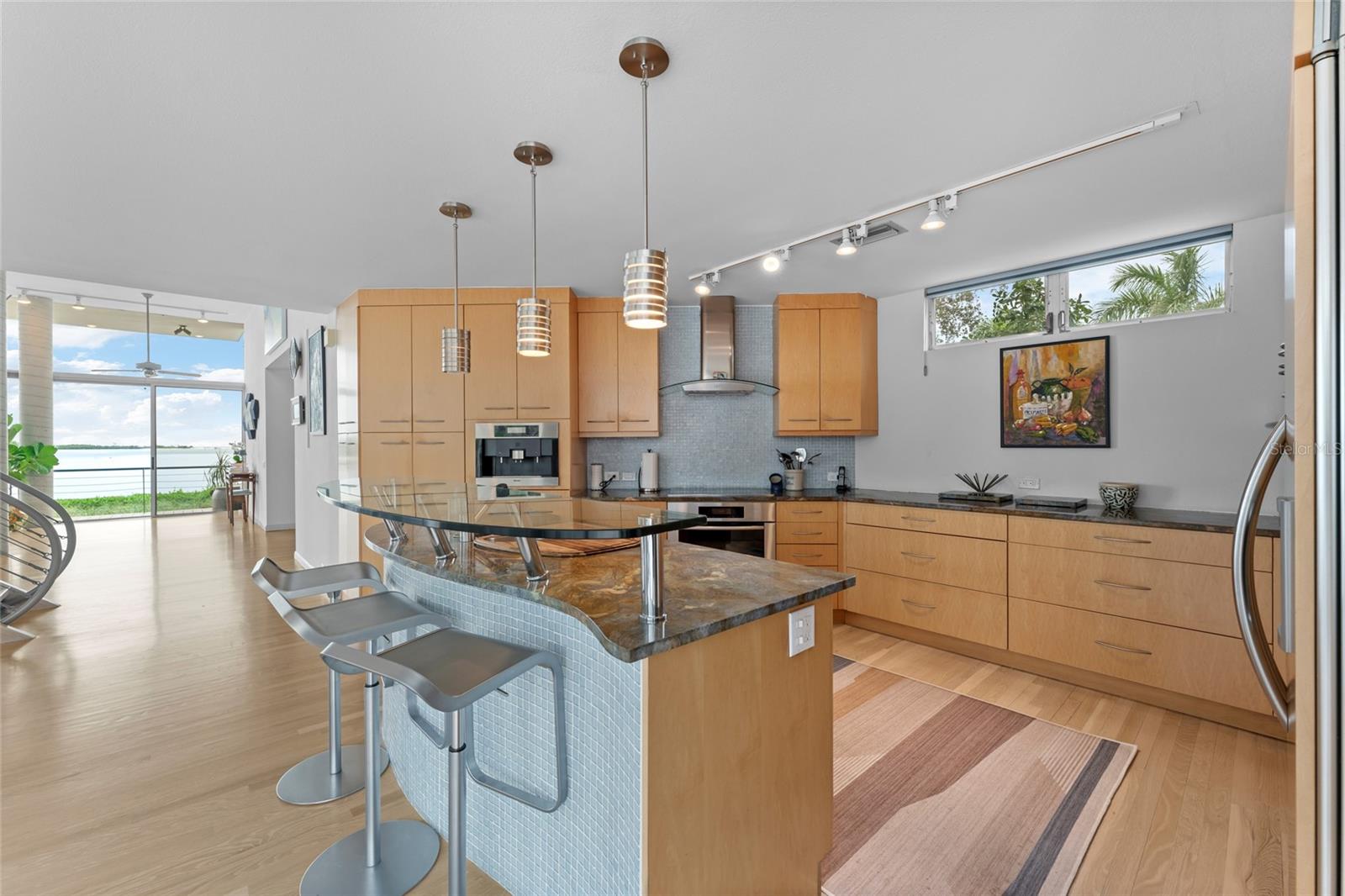 Custom made modern cabinetry with comfortable bar seating and water views.  Notice the transom window for added sunshine with the setting sun!