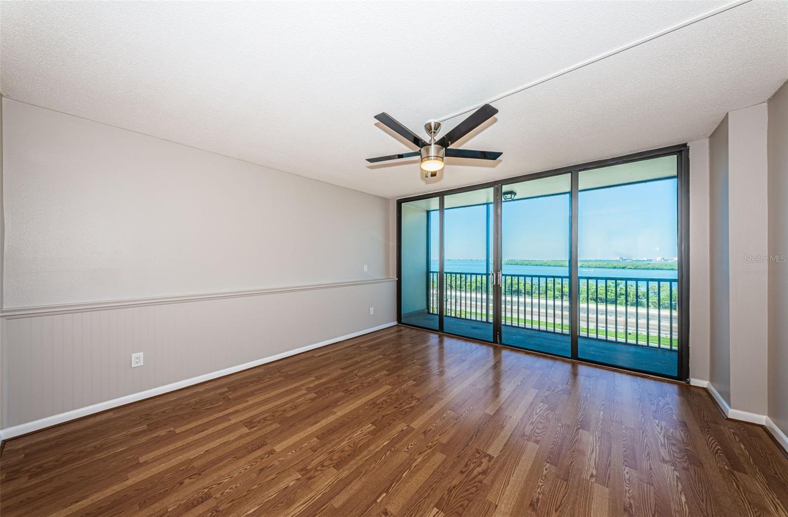 Primary bedroom with balcony and floor to ceiling sliders