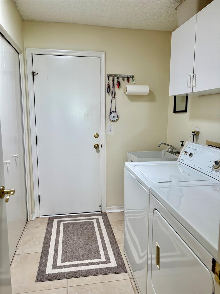 Laundry room with washer/dryer, sink and closet and entry to garage