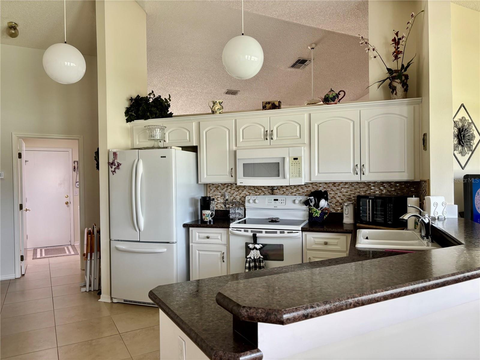 Kitchen with view of laundry room and garage entrance