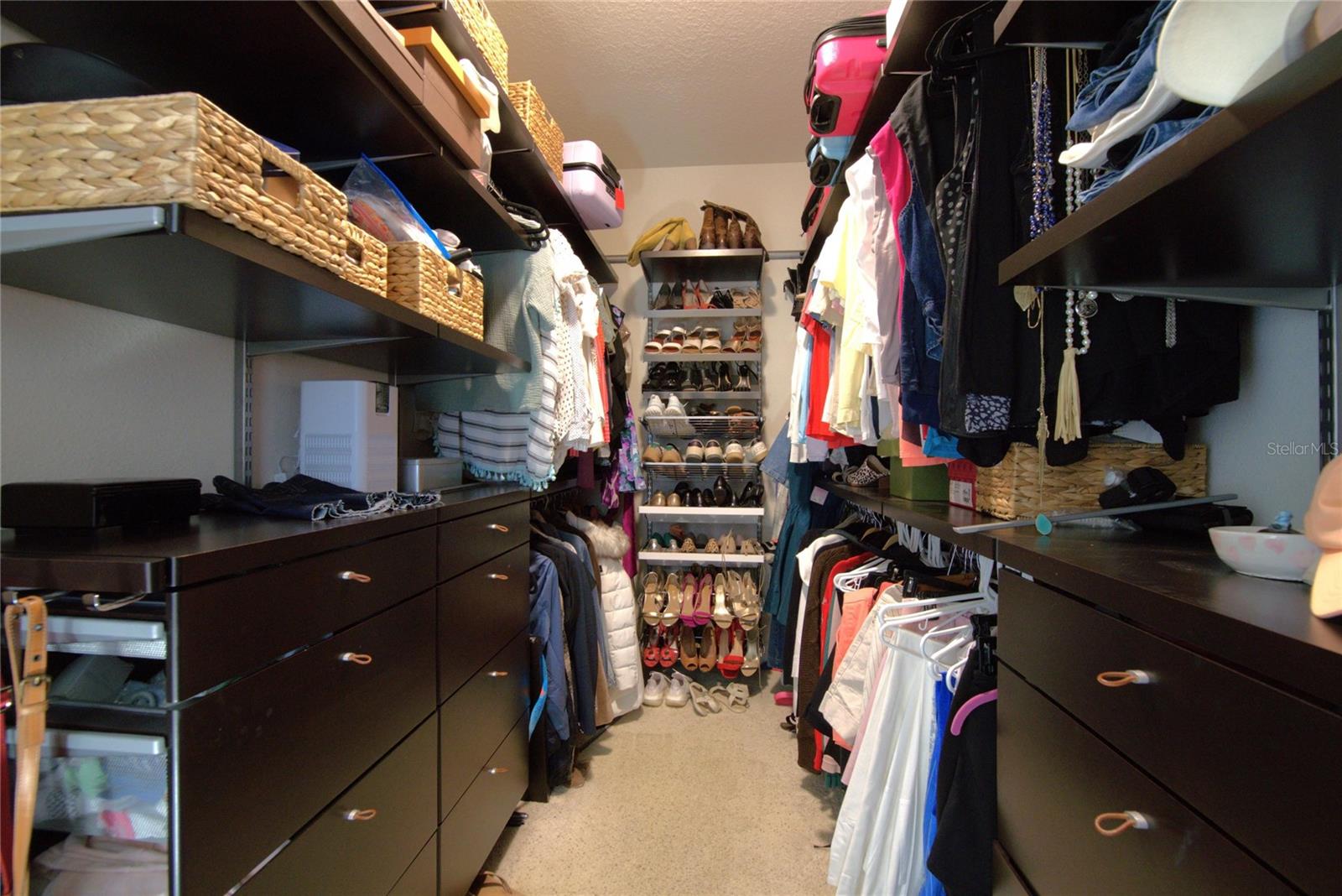 Primary closet with adjustable built ins offering tons of space