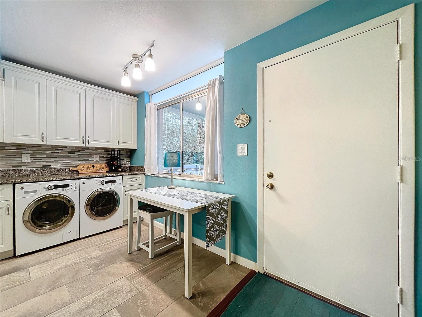 A cozy breakfast bar by the window offers a lovely view of greenery outside, with rear door access for added flexibility.